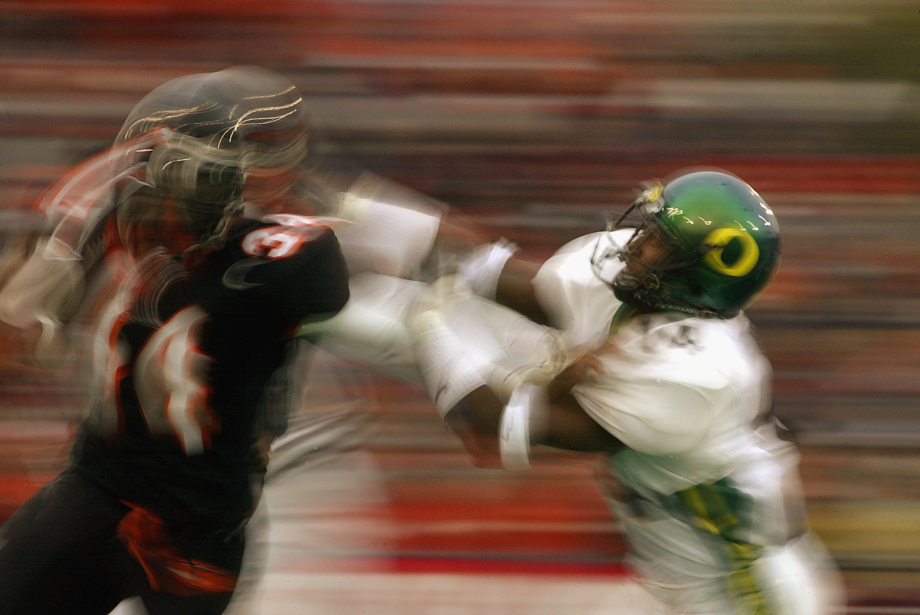 CORVALIS, OR - NOVEMBER 23:  Charles Favroth #11 of the University of Oregon Ducks attempts to tackle Shawn Jackson #34 of the Oregon State University Beavers during the 'Civil War' game at Reser Stadium on November 23, 2003 in Corvalis, Oregon. Oregon St