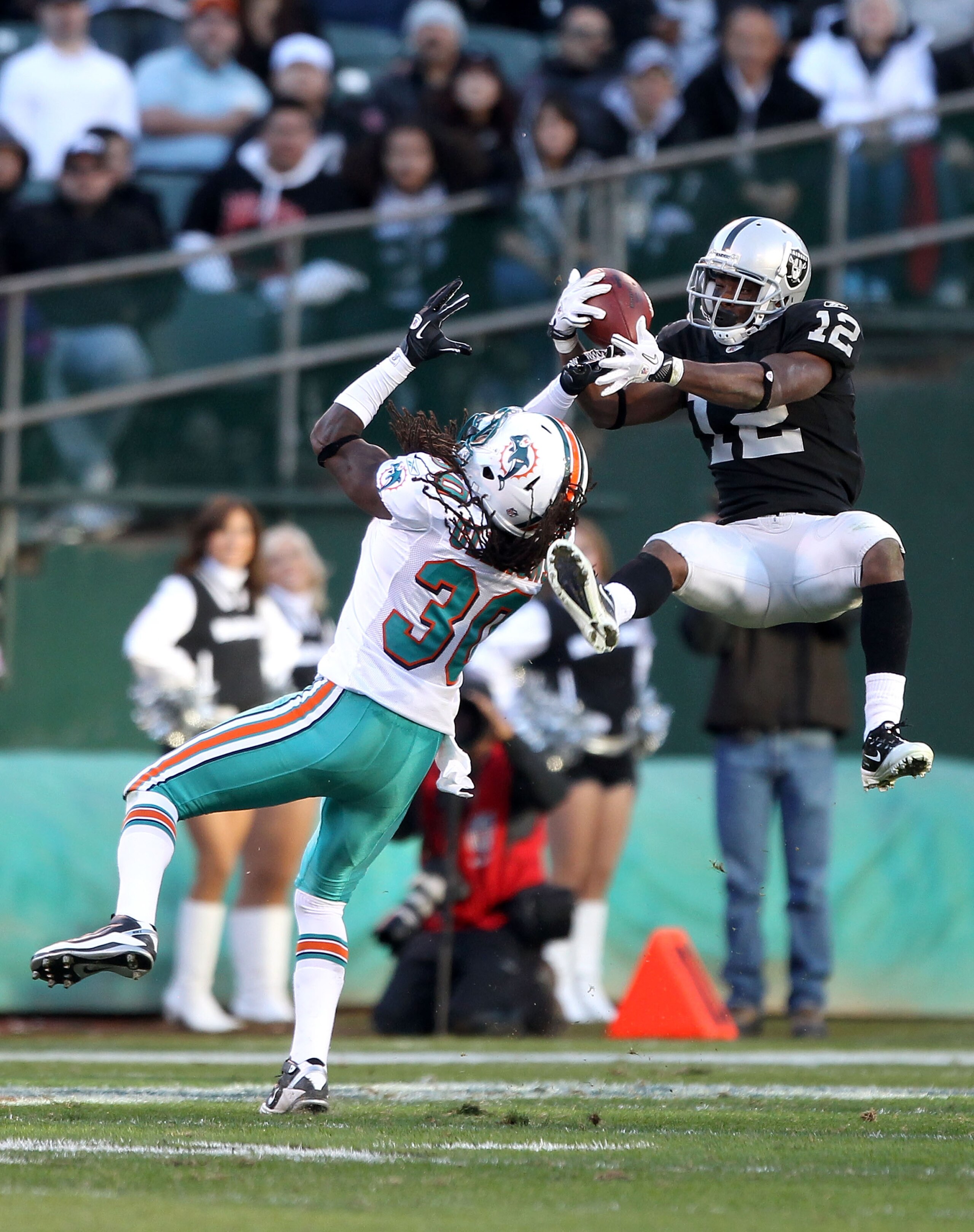 OAKLAND, CA - NOVEMBER 28: Jacoby Ford #12 of the Oakland Raiders catches the ball while defended by Chris Clemons #30 of the Miami Dolphins at Oakland-Alameda County Coliseum on November 28, 2010 in Oakland, California. (Photo by Ezra Shaw/Getty Images OAKLAND, CA - NOVEMBER 28: Jacoby Ford #12 of the Oakland Raiders catches the ball while defended by Chris Clemons #30 of the Miami Dolphins at Oakland-Alameda County Coliseum on November 28, 2010 in Oakland, California. (Photo by Ezra Shaw/Getty Images