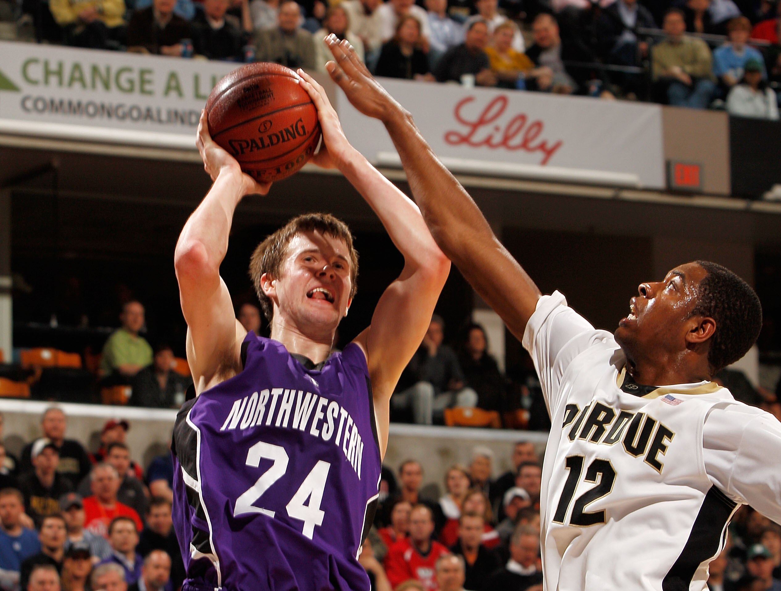 INDIANAPOLIS - MARCH 12:  Forward Kelsey Barlow #12 of the Purdue Boilermakers contests a shot by forward John Shurna #24 of the Northwestern Wildcats during the quarterfinals of the Big Ten Men's Basketball Tournament at Conseco Fieldhouse on March 12, 2