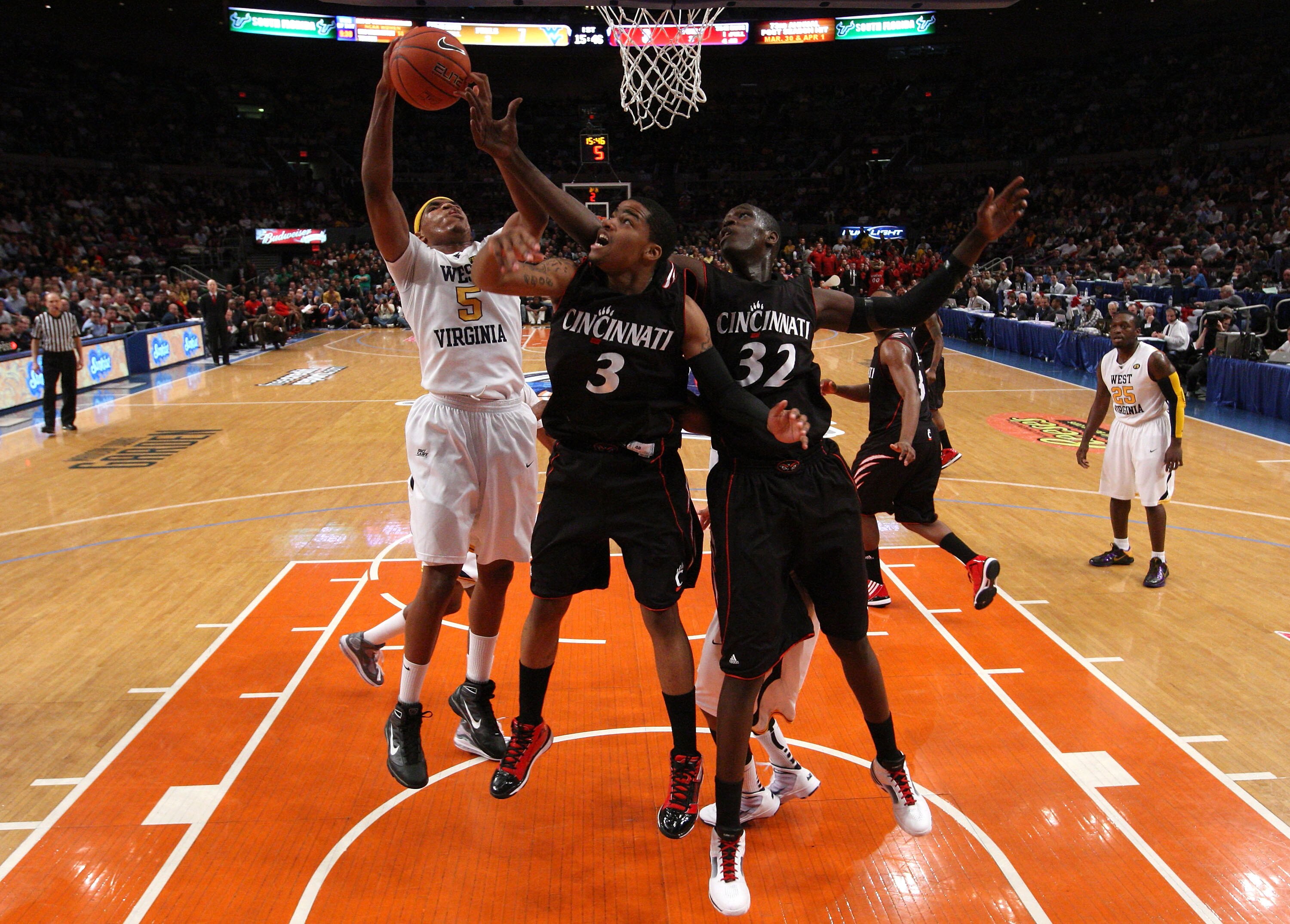 NEW YORK - MARCH 11:  Kevin Jones #5 of the West Virginia Mountaineers goes to the hoop against Dion Dixon #3 and Ibrahima Thomas #32 of the Cincinnati Bearcats during the quarterfinal of the 2010 NCAA Big East Tournament at Madison Square Garden on March