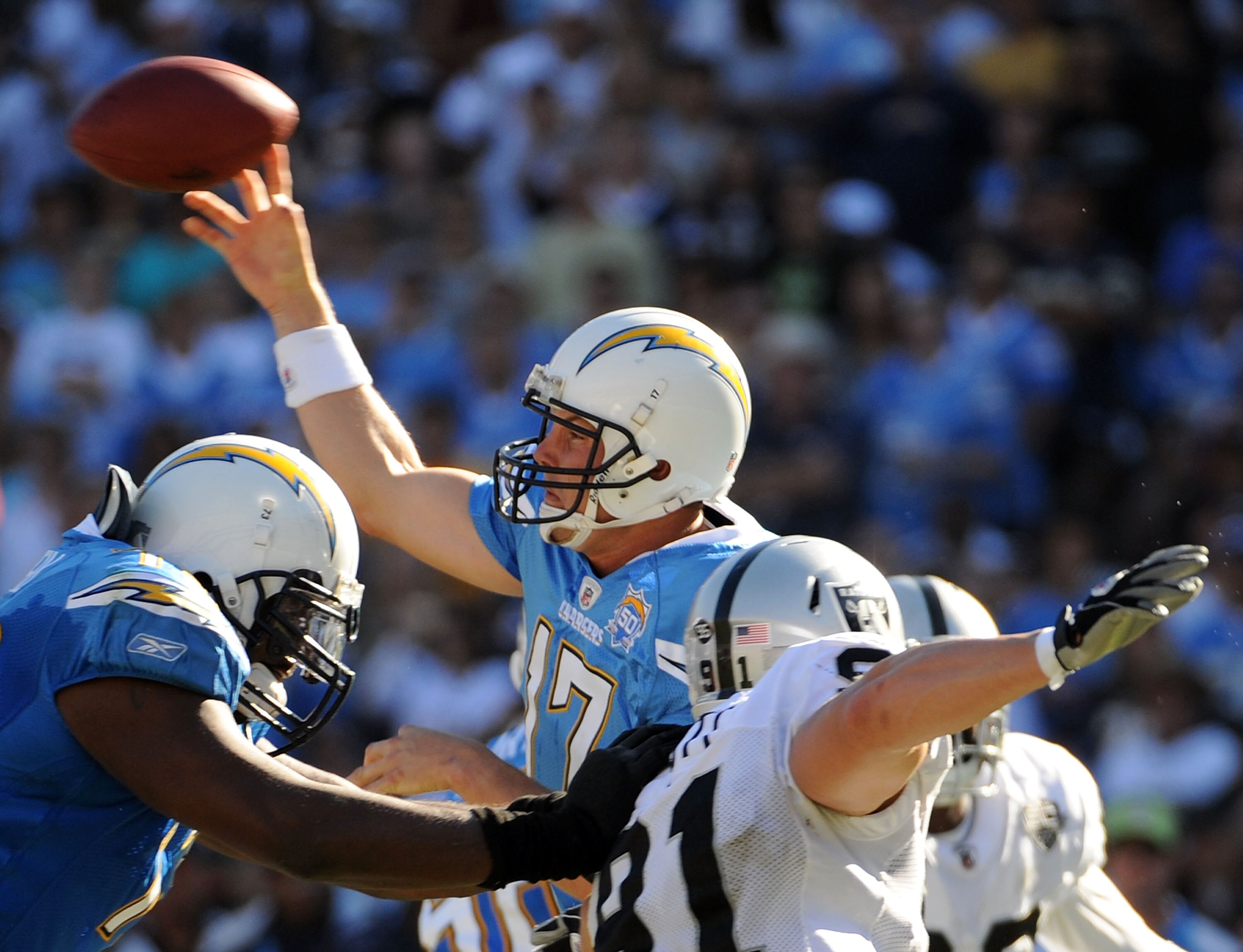 SAN DIEGO - NOVEMBER 01:  Philip Rivers #17 of the San Diego Chargers thorws as he is rushed by Trevor Scott #91 of the Oakland Raiders during the second quarter at Qualcomm Stadium on November 1, 2009 in San Diego California.  (Photo by Harry How/Getty I