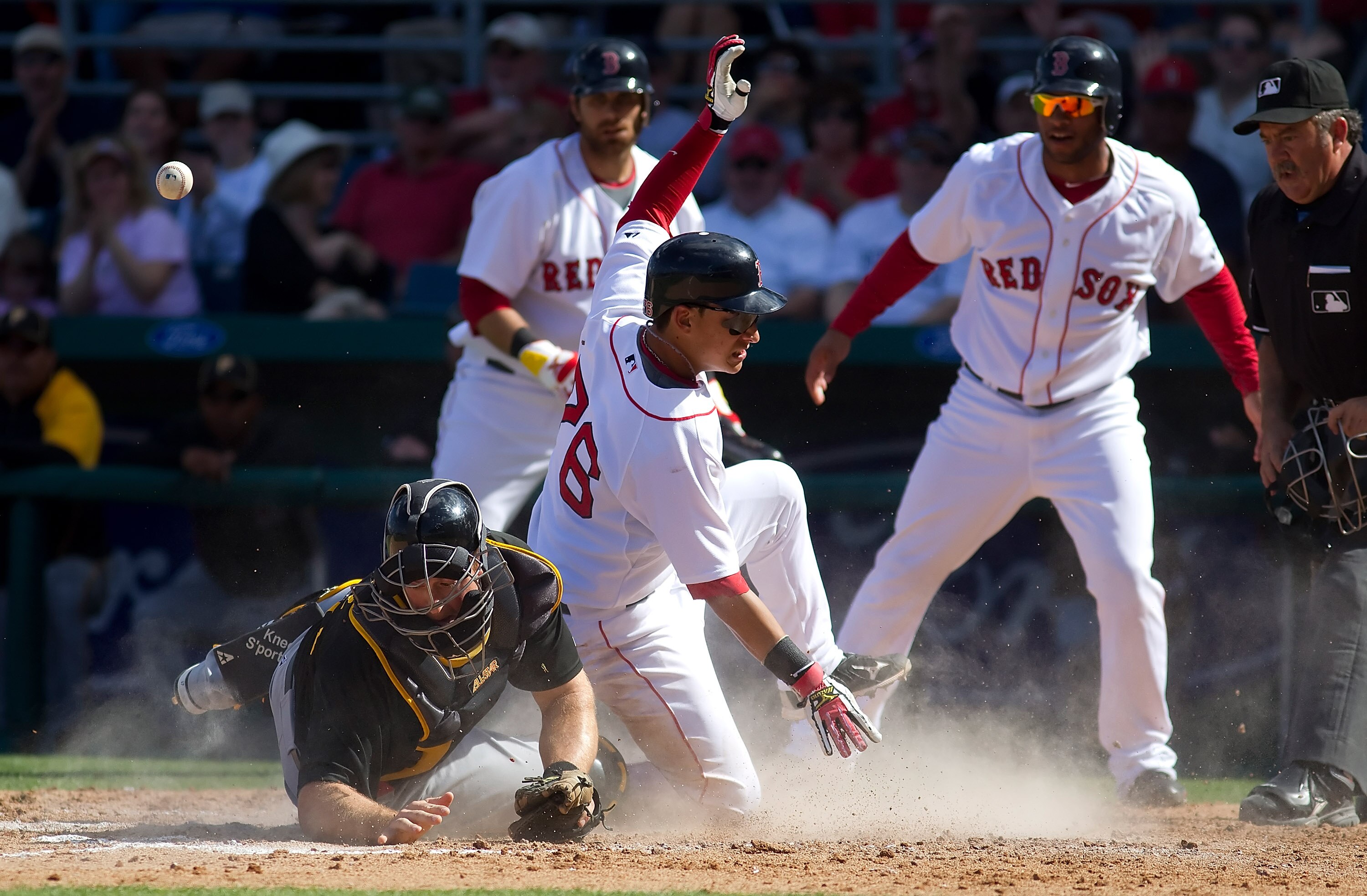 FORT MYERS, FL - MARCH 13:  Catcher Erik Kratz #67 of the Pittsburgh Pirates  cannot handle the throw as infielder Jose Iglesias #76 of the Boston Red Sox scores during a Grapefruit League Spring Training Game at City of Palms Park on March 13, 2010 in Fo