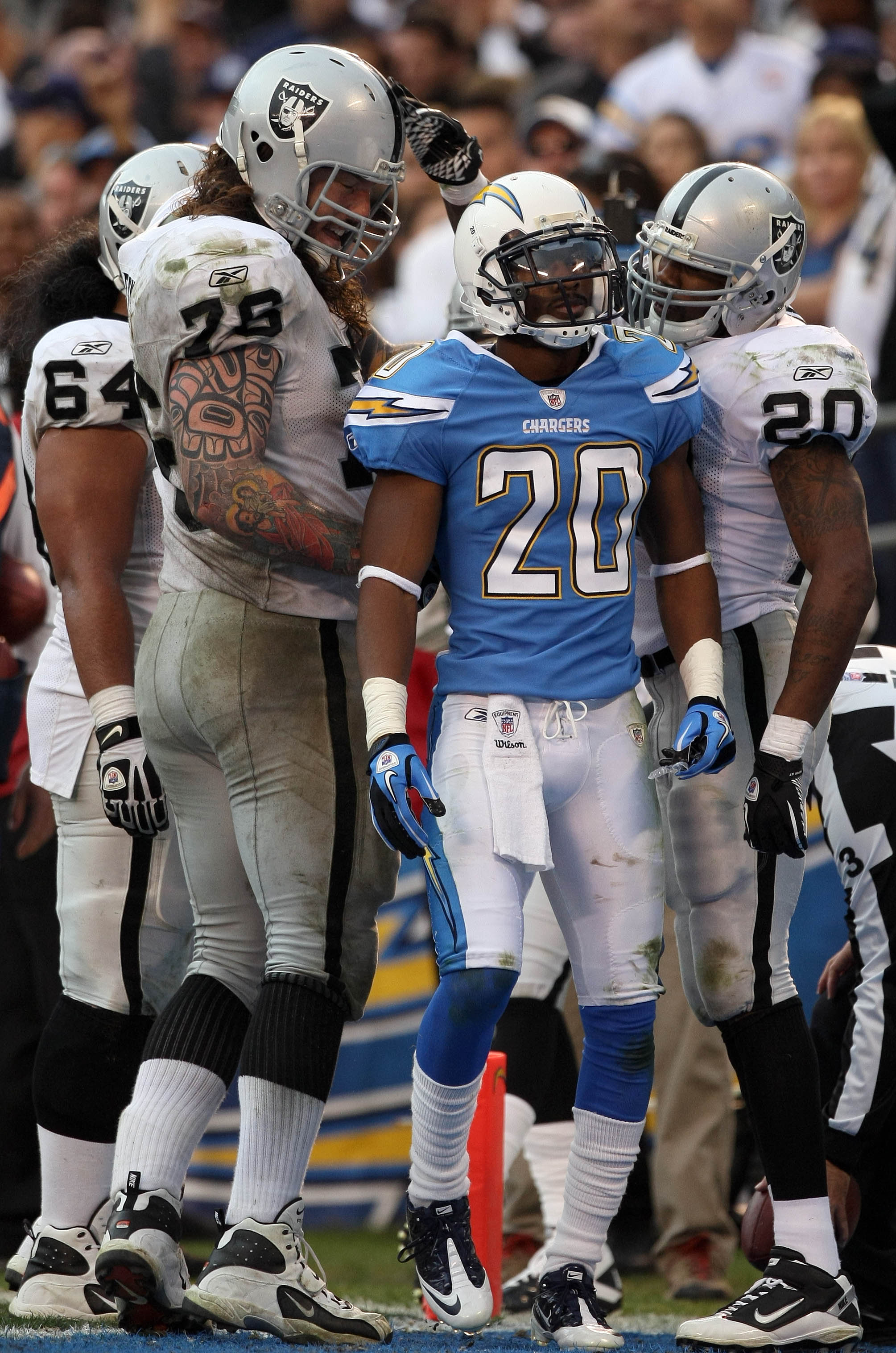 SAN DIEGO, CA - DECEMBER 5: Antoine Cason #20 of the San Diego Chargers looks on as Robert Gallery #76 congratulates teammate Darren McFadden #20 of the Oakland Raiders after McFadden's touchdown during their NFL game at Qualcomm Stadium on December 5, 20