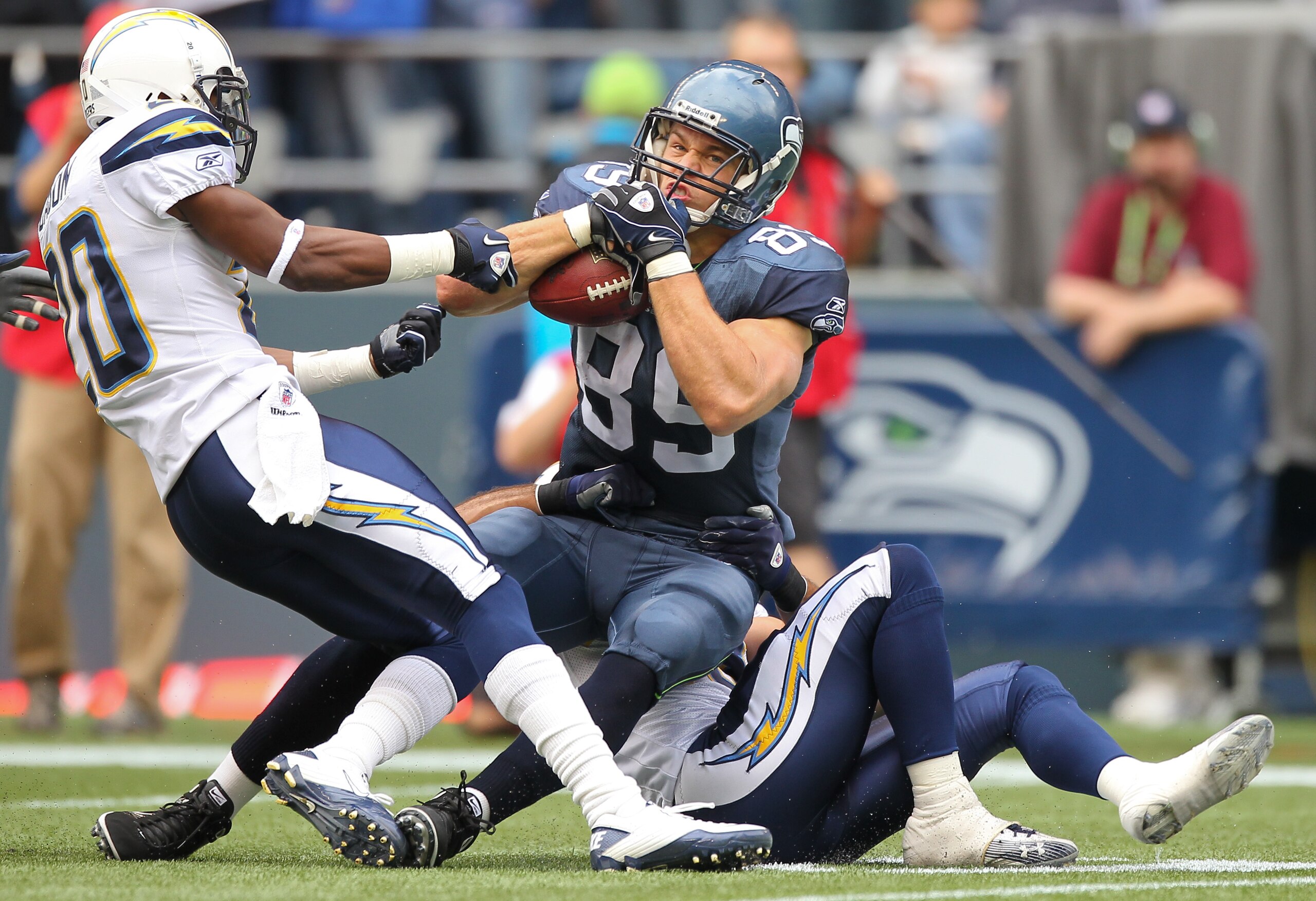 SEATTLE - SEPTEMBER 26:  Tight end John Carlson #89 of the Seattle Seahawks is tackled Steve Gregory #28 and Antoine Cason #20 of the San Diego Chargers at Qwest Field on September 26, 2010 in Seattle, Washington. (Photo by Otto Greule Jr/Getty Images)