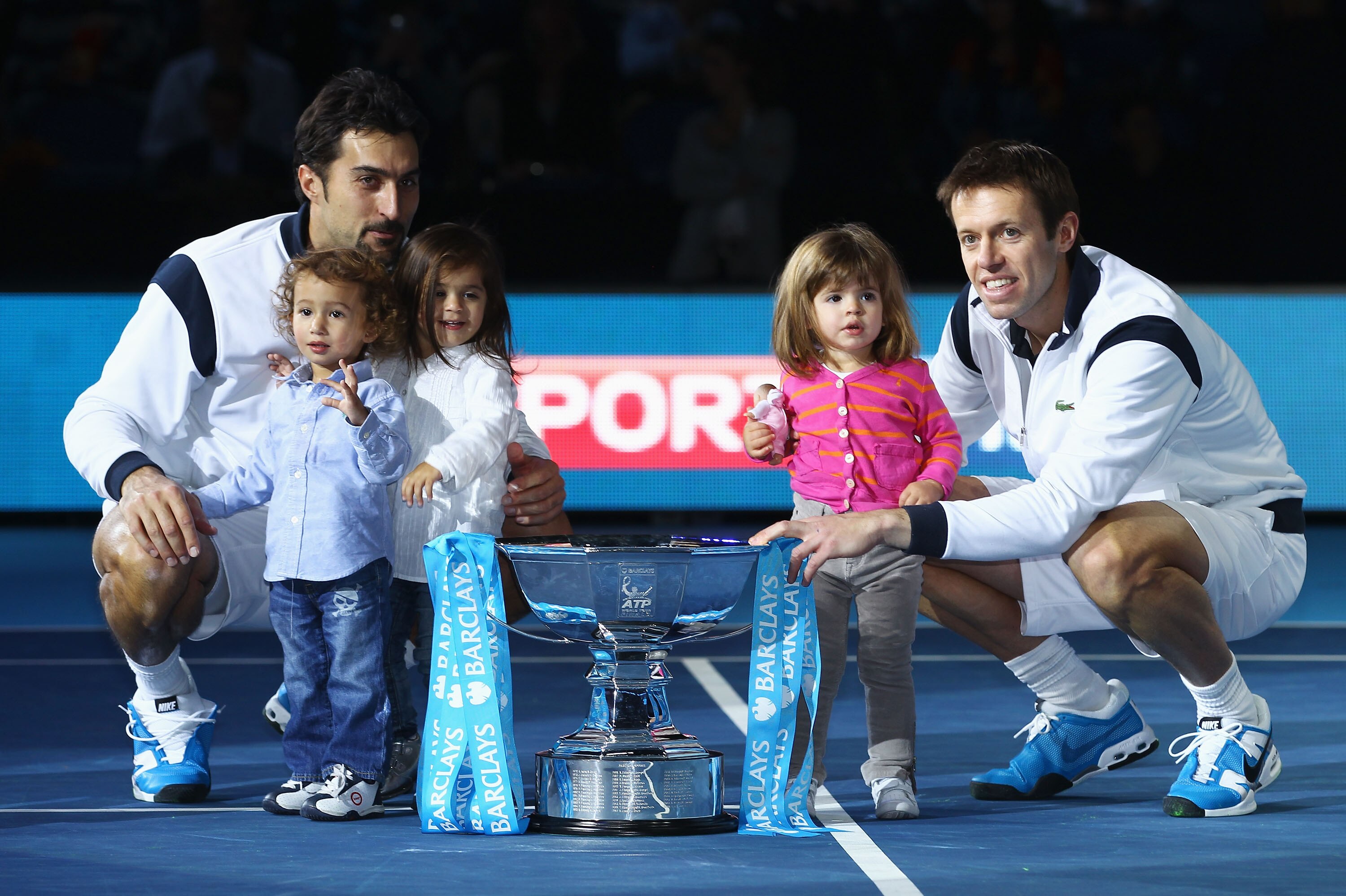 LONDON, ENGLAND - NOVEMBER 28:  Daniel Nestor of Canada (R) and Nenad Zimonjic of Serbia (L) and children pose with the trophy as they celebrate winning the men's doubles final match against Mahesh Bhupathi of India and Max Mirnyi of Belarus during the AT