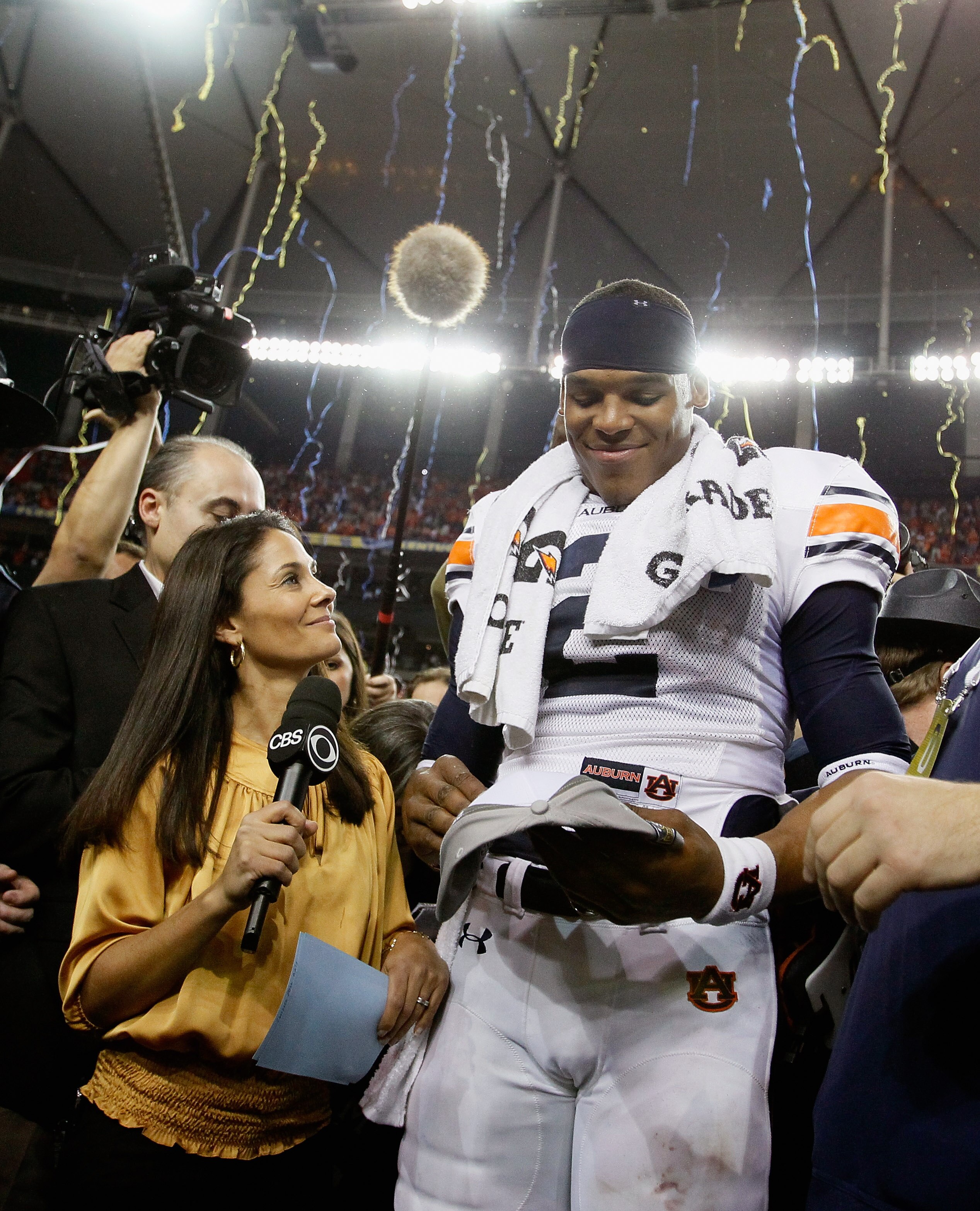 ATLANTA, GA - DECEMBER 04:  CBS sideline reporter Tracy Wolfson waits for an interview as quarterback Cam Newton #2 of the Auburn Tigers celebrates after their 56-17 win over the South Carolina Gamecocks during the 2010 SEC Championship at Georgia Dome on