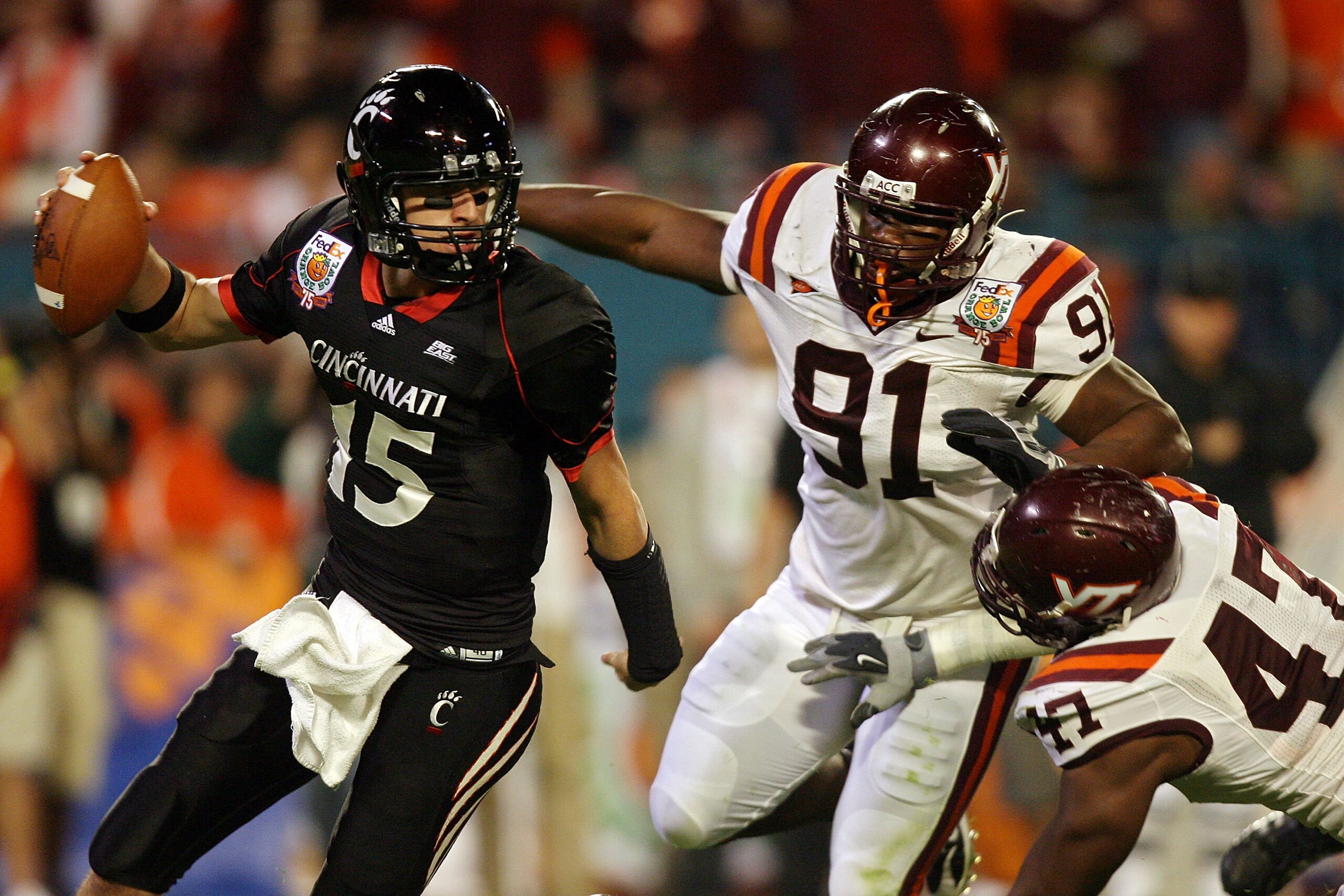 MIAMI - JANUARY 01:  Tony Pike #15 of the Cincinnati Bearcats scambles away from Nekos Brown #47 and John Graves #91 of the Virginia Tech Hokies during the FedEx Orange Bowl at Dolphin Stadium on January 1, 2009 in Miami, Florida.  (Photo by Doug Benc/Get