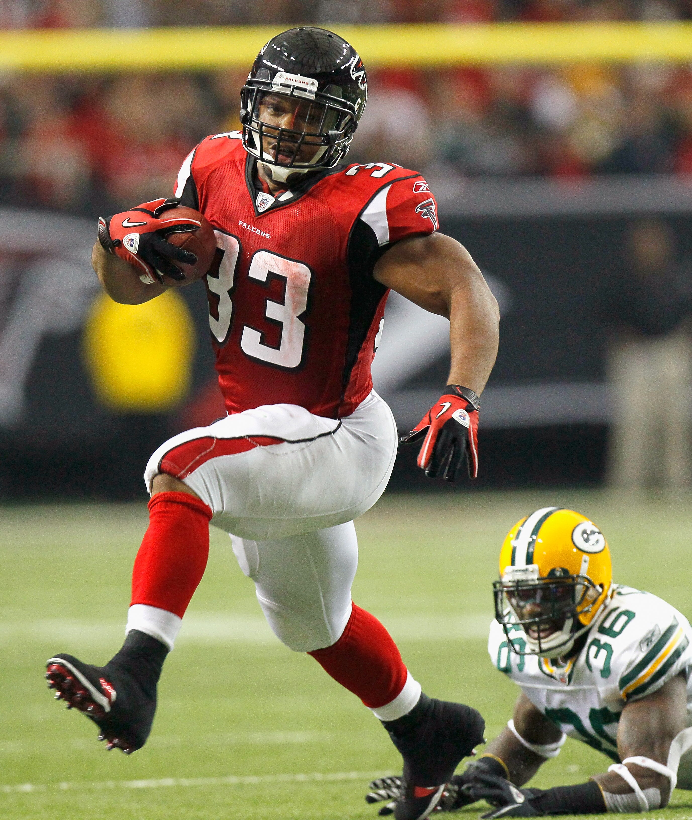 ATLANTA - NOVEMBER 28:  Michael Turner #33 of the Atlanta Falcons rushes rushes upfield away from Nick Collins #36 of the Green Bay Packers at Georgia Dome on November 28, 2010 in Atlanta, Georgia.  (Photo by Kevin C. Cox/Getty Images)