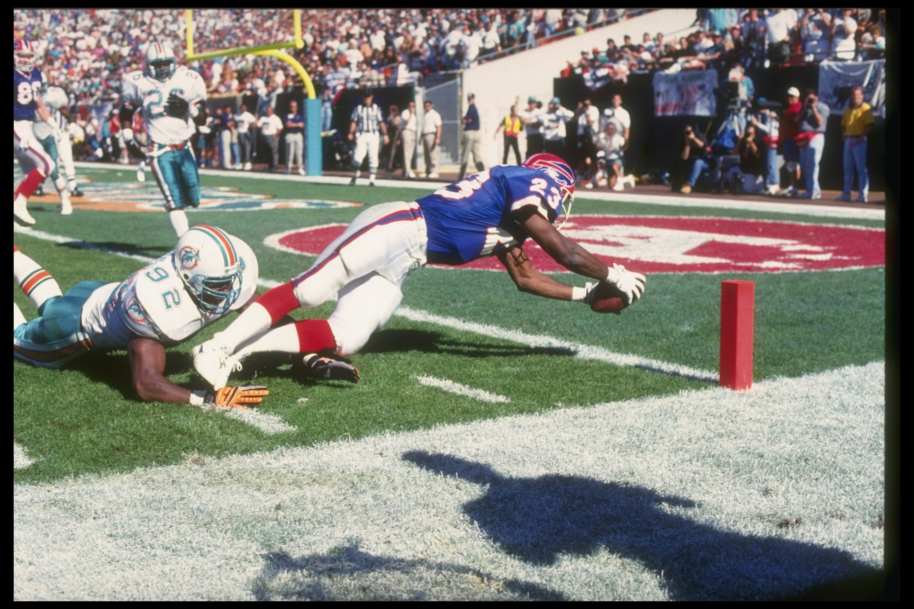 17 Jan 1993: Running back Kenneth Davis of the Buffalo Bills (right) lunges for the end zone as Miami Dolphins linebacker David Griggs tackles him during a playoff game at Rich Stadium in Orchard Park, New York. The Bills won the game, 29-10.