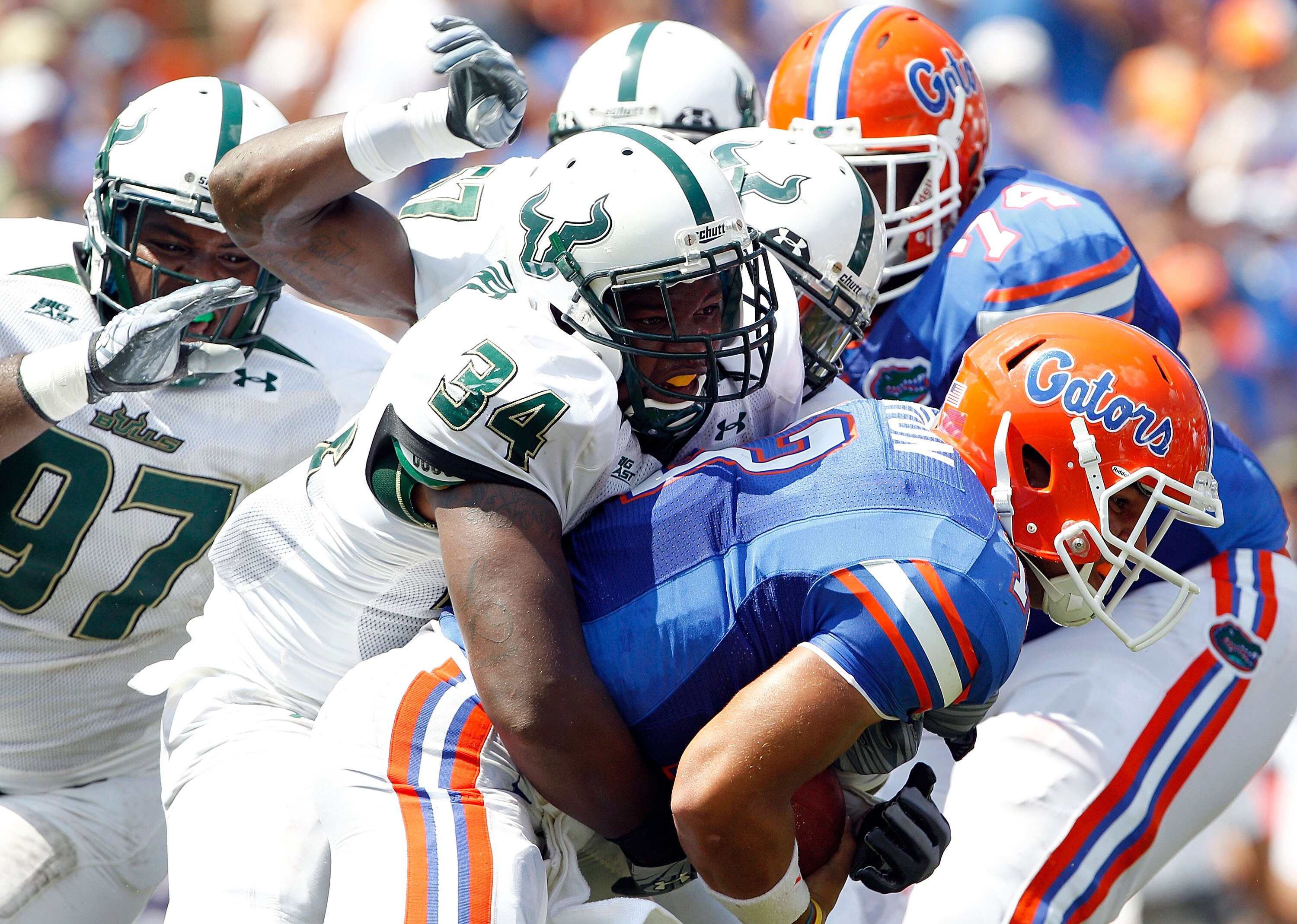 GAINESVILLE, FL - SEPTEMBER 11:  Quarterback Trey Burton #13 of the Florida Gators is tackled by Devekeyan Lattimore #34 of the South Florida Bulls  during a game at Ben Hill Griffin Stadium on September 11, 2010 in Gainesville, Florida.  (Photo by Sam Gr