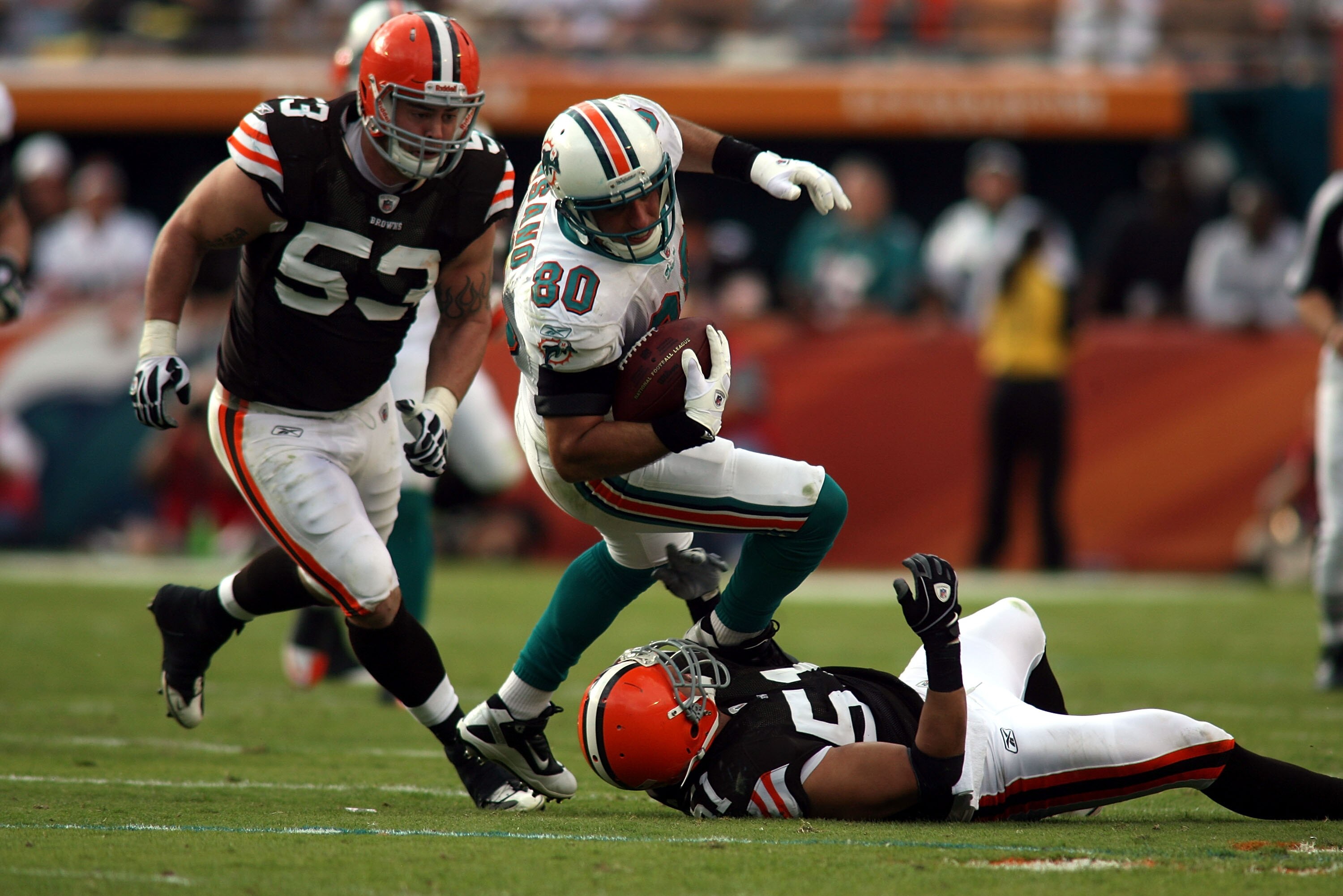 MIAMI - DECEMBER 05:  Tight end Anthony Fasano #80 of the Miami Dolphins is brought down by Linebackers Matt Roth #53 and Chris Gocong #51 of the Cleveland Browns at Sun Life Stadium on December 5, 2010 in Miami, Florida. Cleveland defeated miami 13-10.