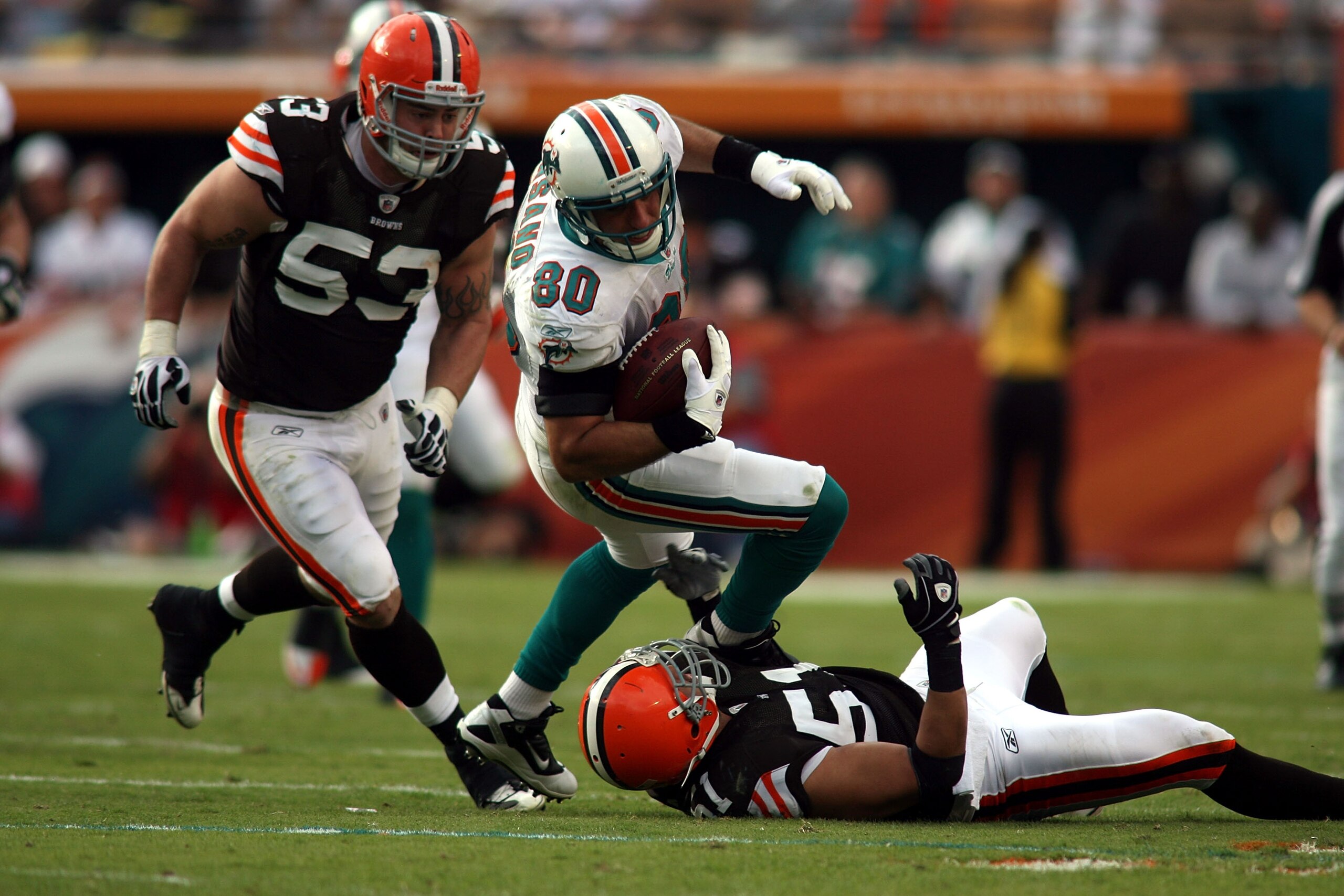 MIAMI - DECEMBER 05:  Tight end Anthony Fasano #80 of the Miami Dolphins is brought down by Linebackers Matt Roth #53 and Chris Gocong #51 of the Cleveland Browns at Sun Life Stadium on December 5, 2010 in Miami, Florida. Cleveland defeated miami 13-10.
