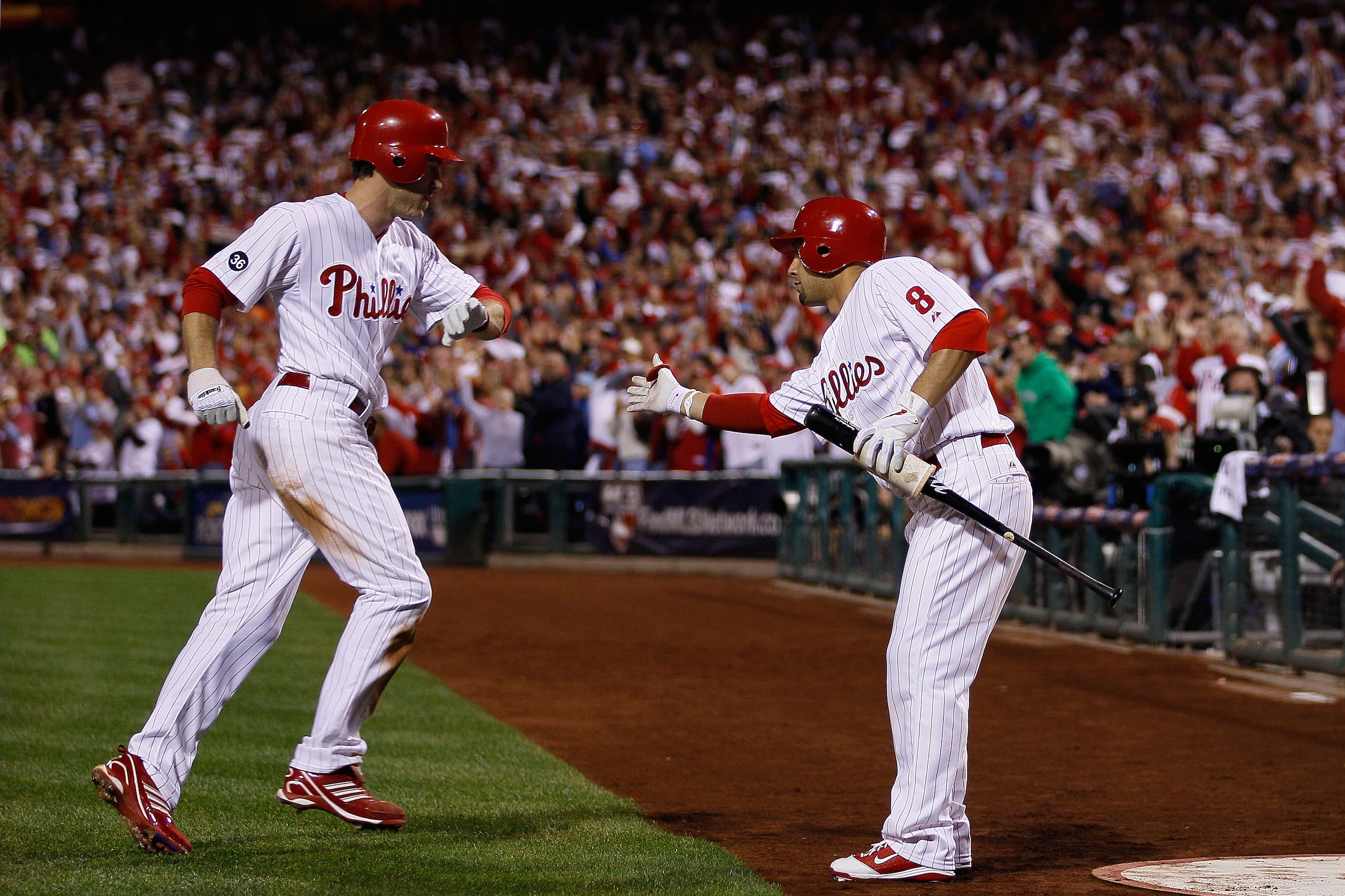PHILADELPHIA - OCTOBER 23:  Chase Utley #26 of the Philadelphia Phillies is congratulated by Shane Victorino #8 after scoring on a first inning sacrifice fly by Jayson Werth against the San Francisco Giants in Game Six of the NLCS during the 2010 MLB Play