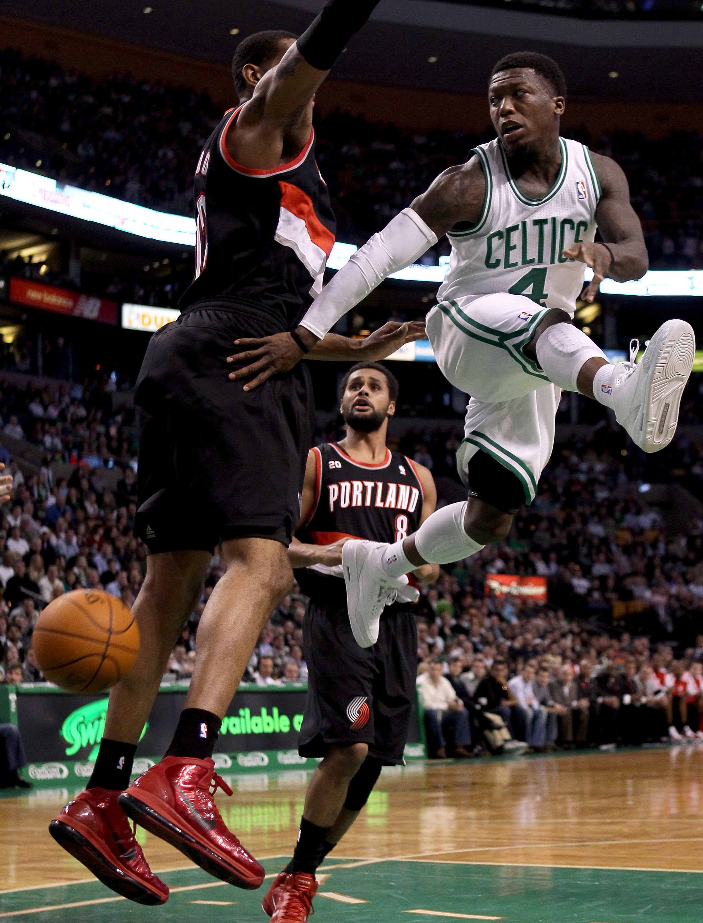 BOSTON - DECEMBER 01:  Nate Robinson #4 of the Boston Celtics passes the ball as LaMarcus Aldridge #12 of the Portland Trailblazers defends on December 1, 2010 at the TD Garden in Boston, Massachusetts.  NOTE TO USER: User expressly acknowledges and agree