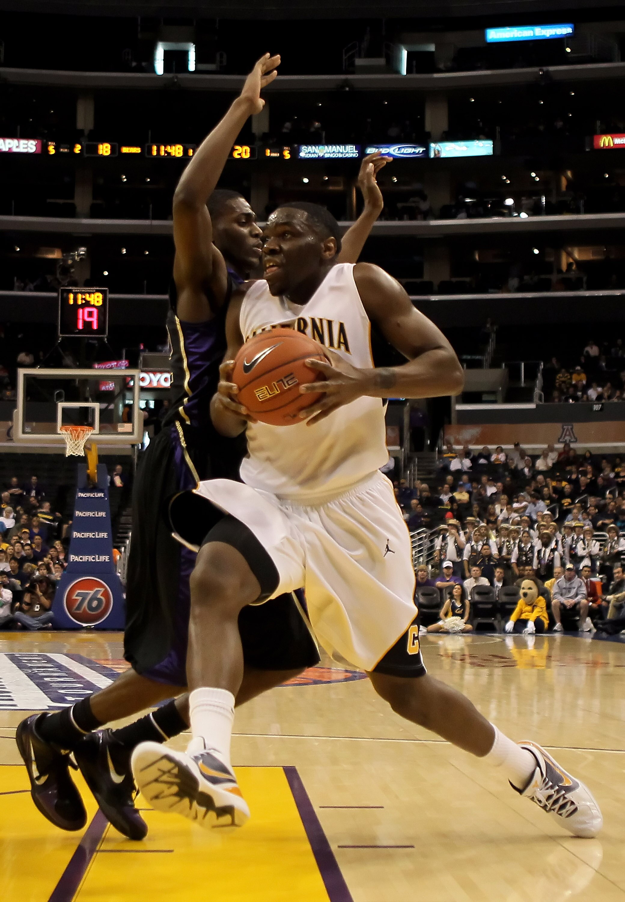 LOS ANGELES, CA - MARCH 13:  Theo Robinson #24 of the Cal Golden Bears drives to the basket while being defended by Justin Holiday #22 of the Washington Huskies in the first half during the championship game of the Pac-10 Basketball Tournament at Staples