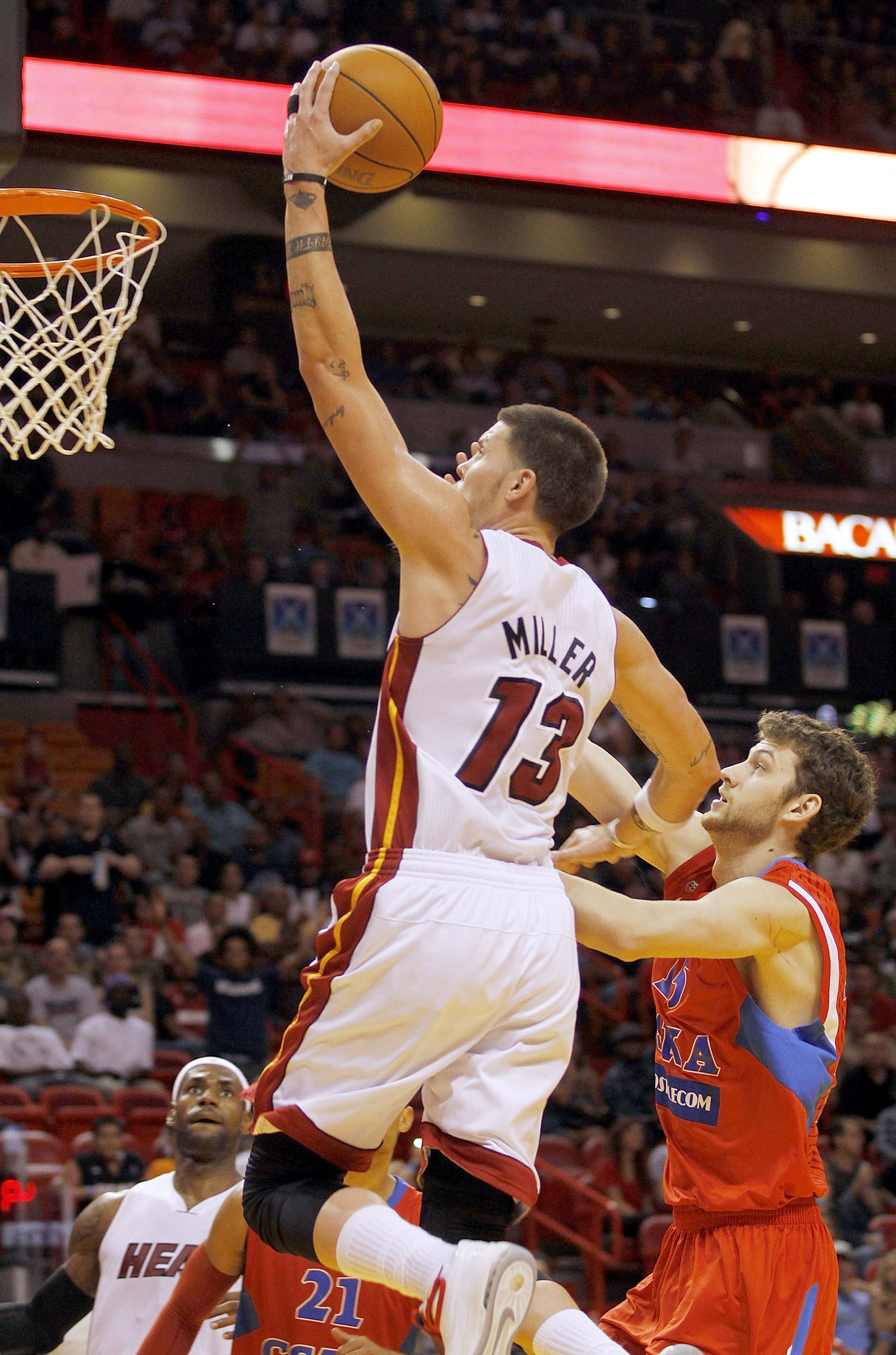 MIAMI - OCTOBER 12:  Forward Mike Miller #13 of the Miami Heat scores over forward Artem Zabelin #15 of CSKA Moscow on October 12, 2010 in Miami, Florida.  Miami heat won 96-85 over CSKA Moscow.  NOTE TO USER: User expressly acknowledges and agrees that,