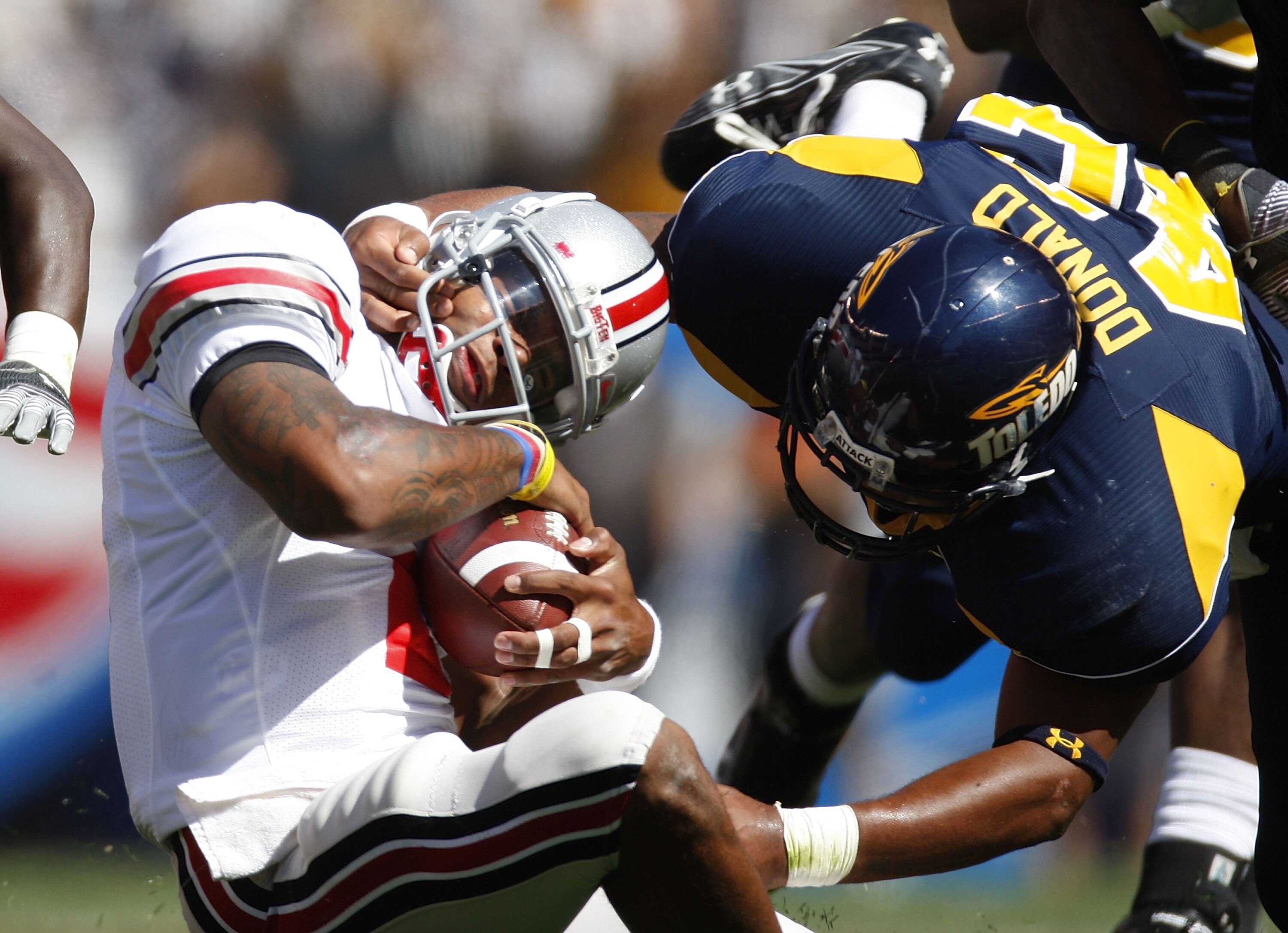 CLEVELAND - SEPTEMBER 19:  Terrelle Pryor #2 of the Ohio State Buckeyes gets tackled by Archie Donald #42 of the Toledeo Rockets on September 19, 2009 at Cleveland Browns Stadium in Cleveland, Ohio.  (Photo by Gregory Shamus/Getty Images)