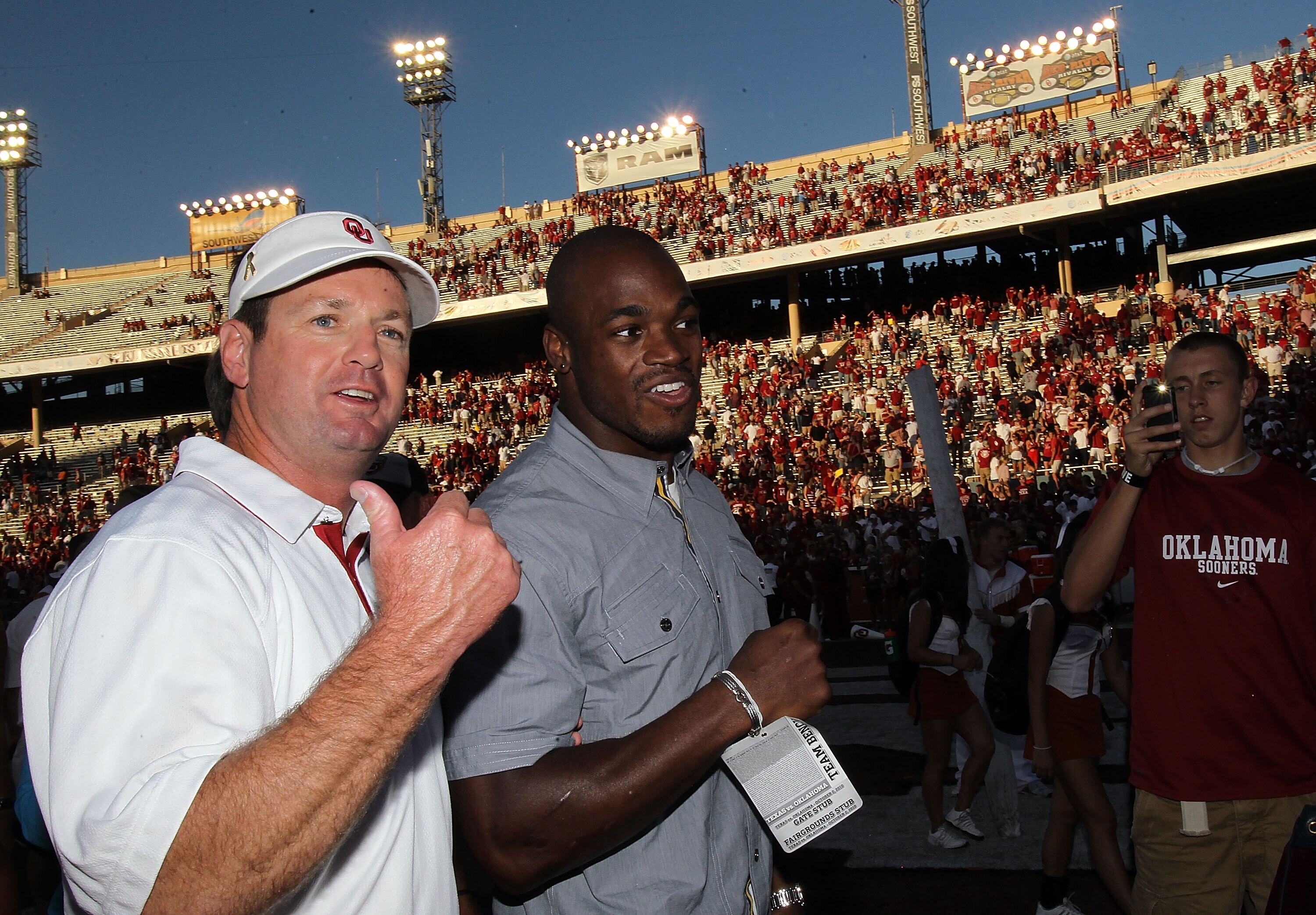 DALLAS - OCTOBER 02:  Head coach Bob Stoops of the Oklahoma Sooners walks off the field with Adrian Peterson of the Minnesota Vikings after a 28-20 win against the Texas Longhorns at the Cotton Bowl on October 2, 2010 in Dallas, Texas.  (Photo by Ronald M