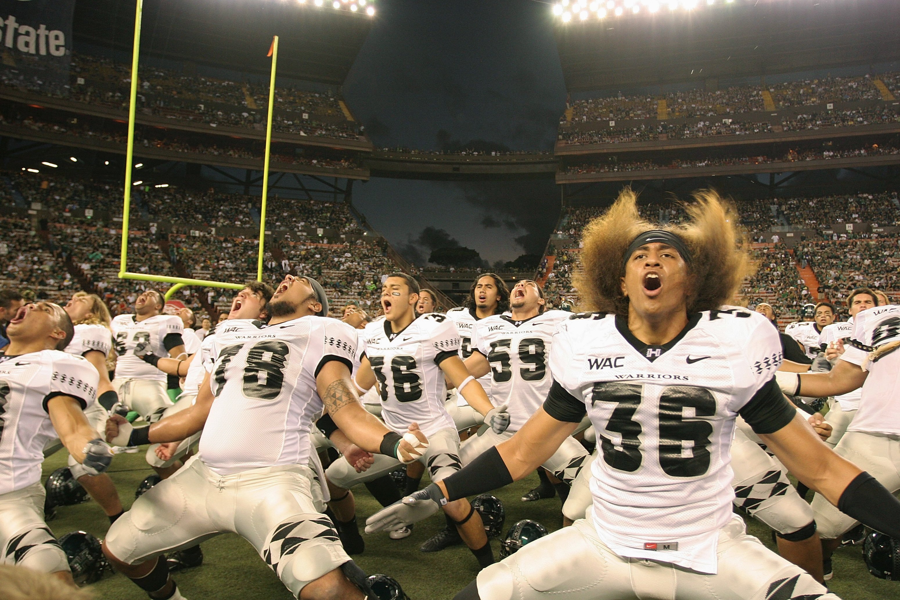 HONOLULU - DECEMBER 2:  Viliami Nauahi #36 (right), Greg Salas #36 (center), Keoni Steinhoff #78 (left) and other players of the Hawaii Warriors perform the Warrior dance, the Haka, before the game against the Washington Huskies on December 1, 2007 at Alo