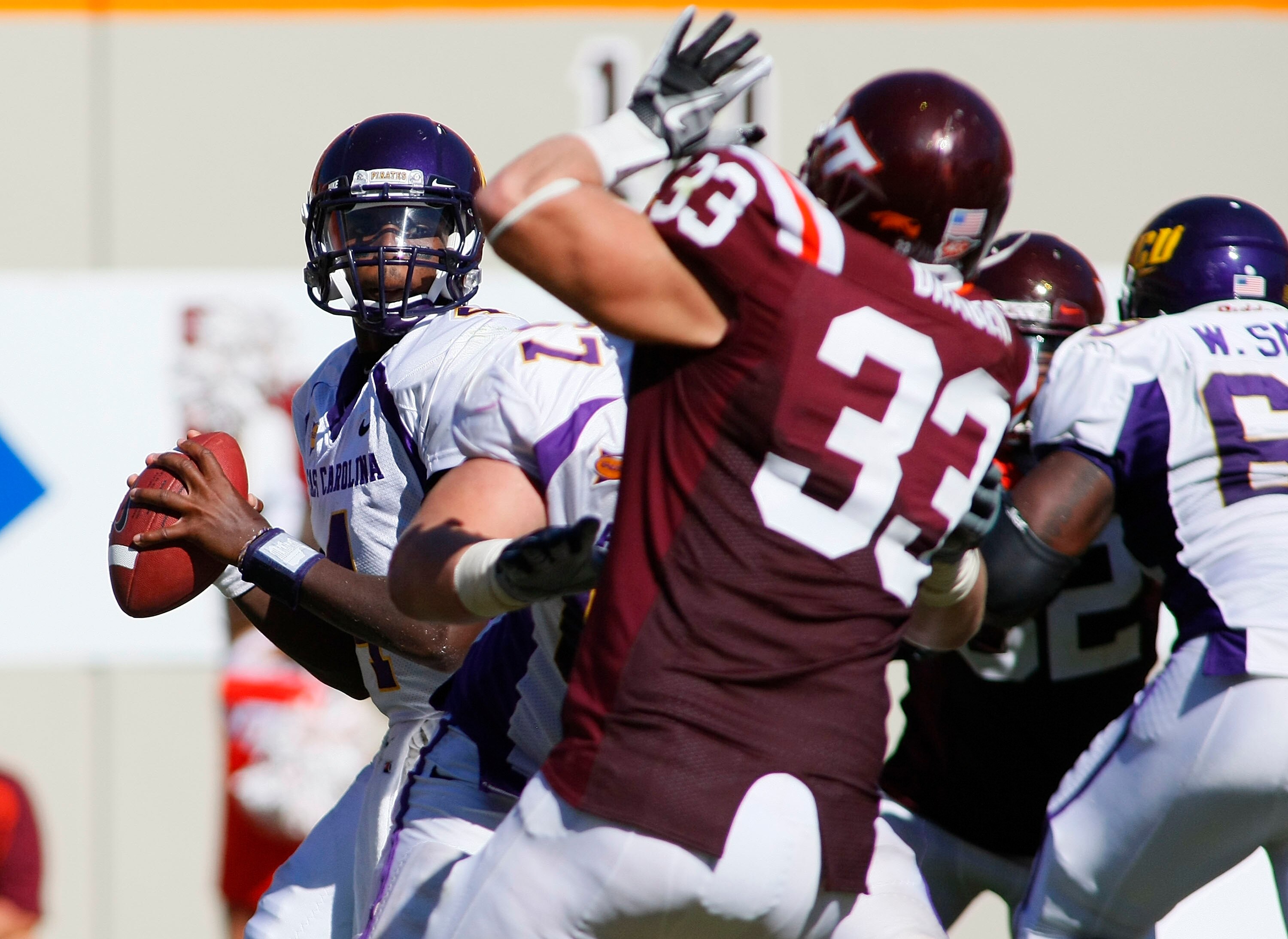 BLACKSBURG, VA - SEPTEMBER 18: Quarterback Dominique Davis #4 of the East Carolina Pirates prepares to pass the ball as defensive end Chris Drager #33 of the Virginia Tech Hokies defends at Lane Stadium on September 18, 2010 in Blacksburg, Virginia.  (Pho