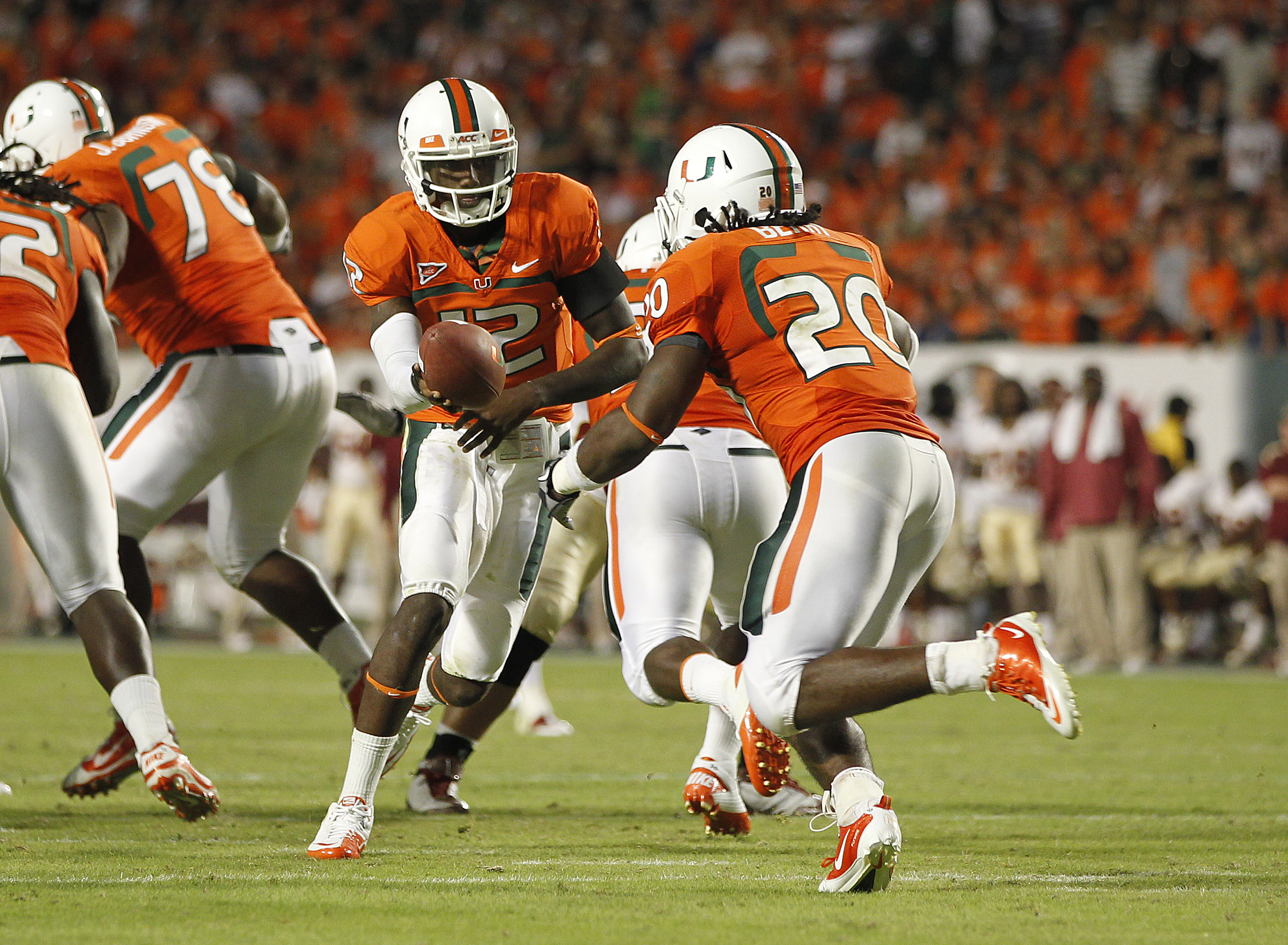 MIAMI, FL - OCTOBER 9: Jacory Harris #12 hands the ball off to Damien Berry #20 of the Miami Hurricanes against the Florida State Seminoles on October 9, 2010 at Sun Life Stadium in Miami, Florida. The Seminoles defeated the Hurricanes 45-17. (Photo by Jo
