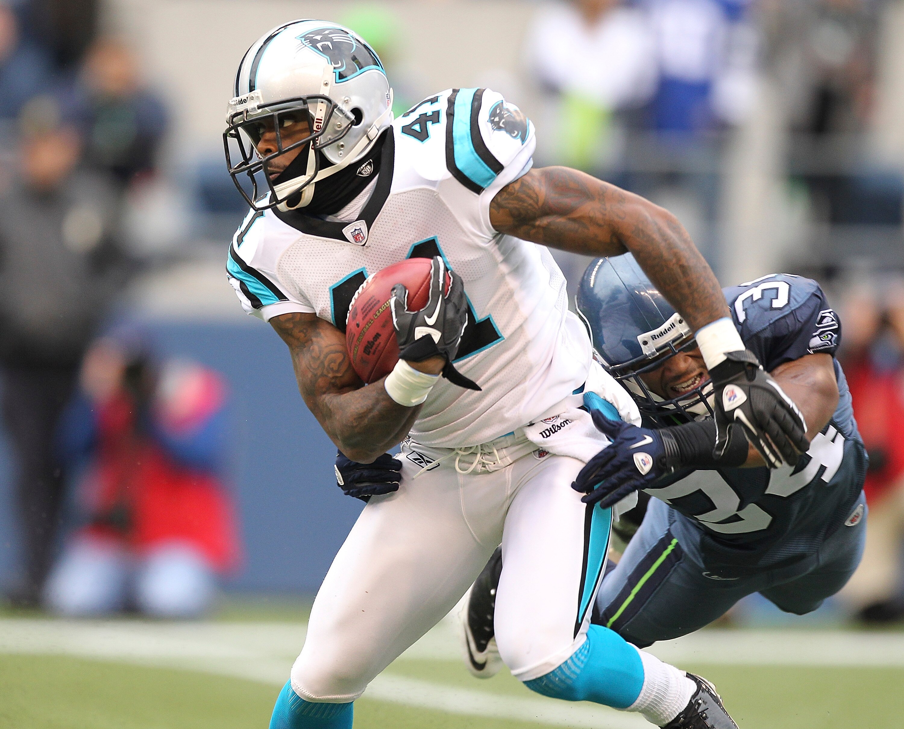 SEATTLE, WA - DECEMBER 05:  Punt returner Captain Munnerlyn #41 of the Carolina Panthers rushes against Roy Lewis #34 of the Seattle Seahawks at Qwest Field on December 5, 2010 in Seattle, Washington. The Seahawks defeated the Panthers 31-14. (Photo by Ot