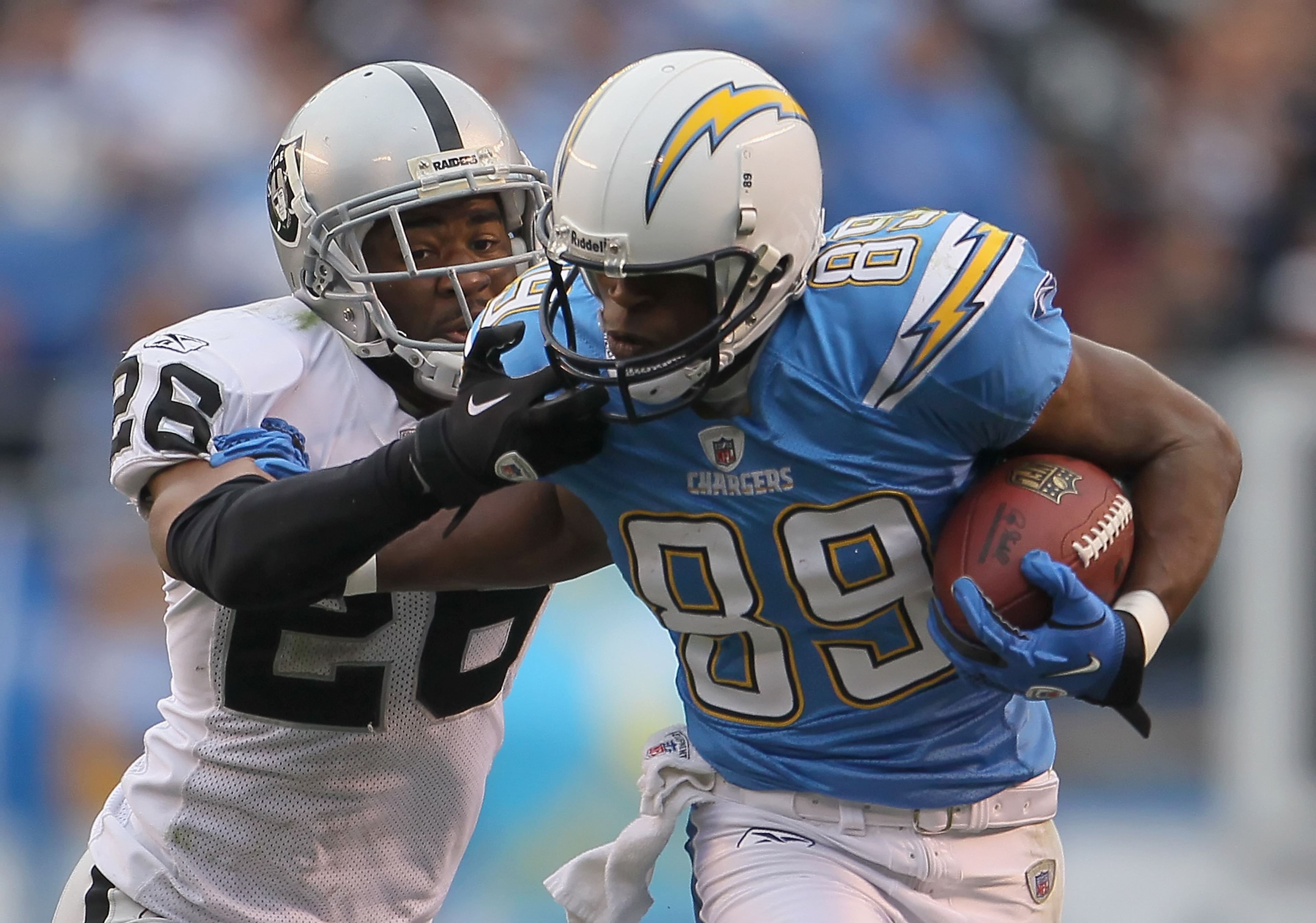SAN DIEGO - DECEMBER 05:  Stanford Routt #26 of the Oakland Raiders grabs the face mask of Seyi Ajirotutu #89 of the San Diego Chargers in an attempt to bring him down in the third quarter at Qualcomm Stadium on December 5, 2010 in San Diego, California.