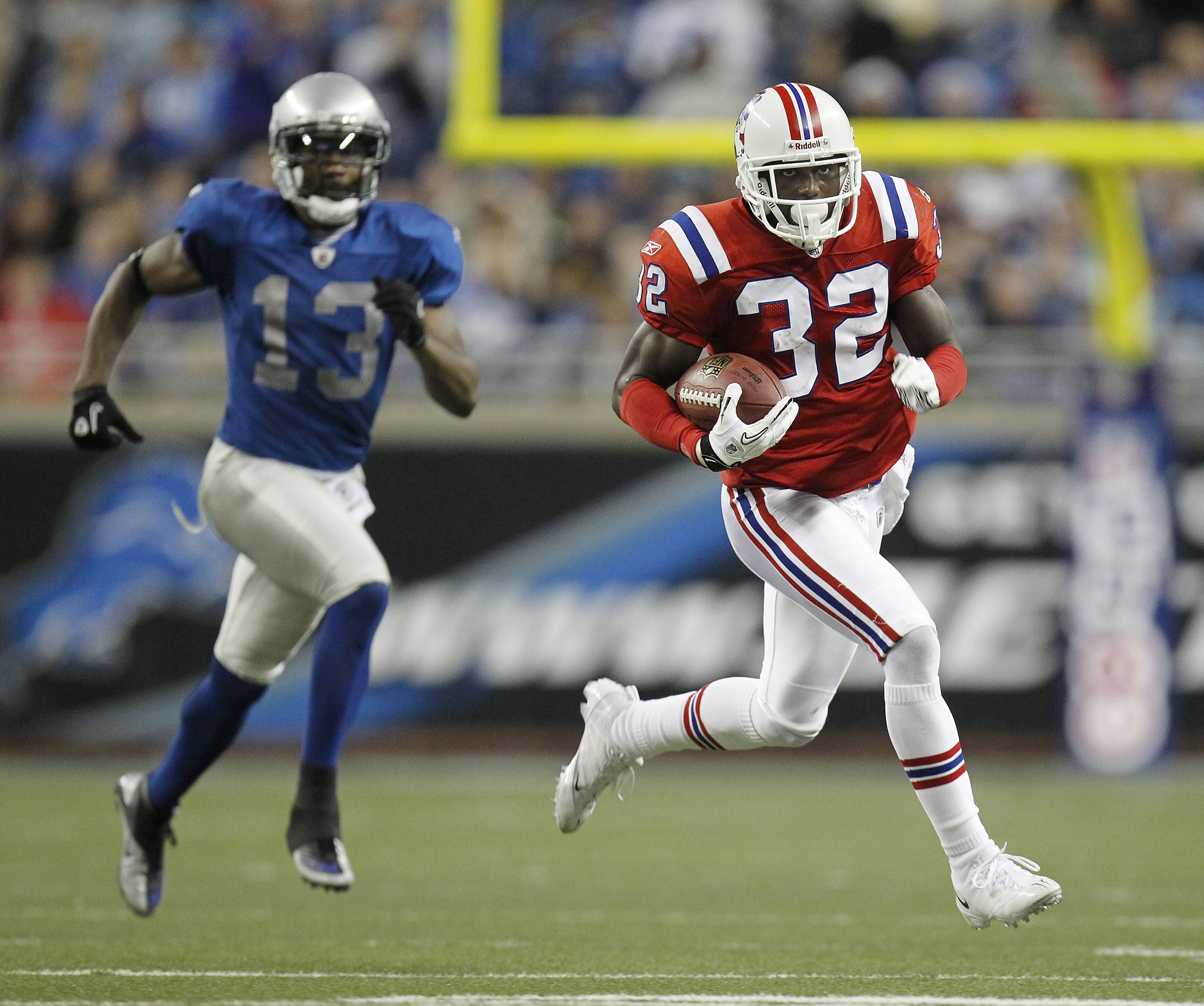 DETROIT - NOVEMBER 25:  Devin McCourty #32 of the New England Patriots returns a fourth quarter interception in front of Nate Burleson #13 of the Detroit Lions on November 25, 2010 at Ford Field in Detroit, Michigan. New England won the game 45-24.  (Phot