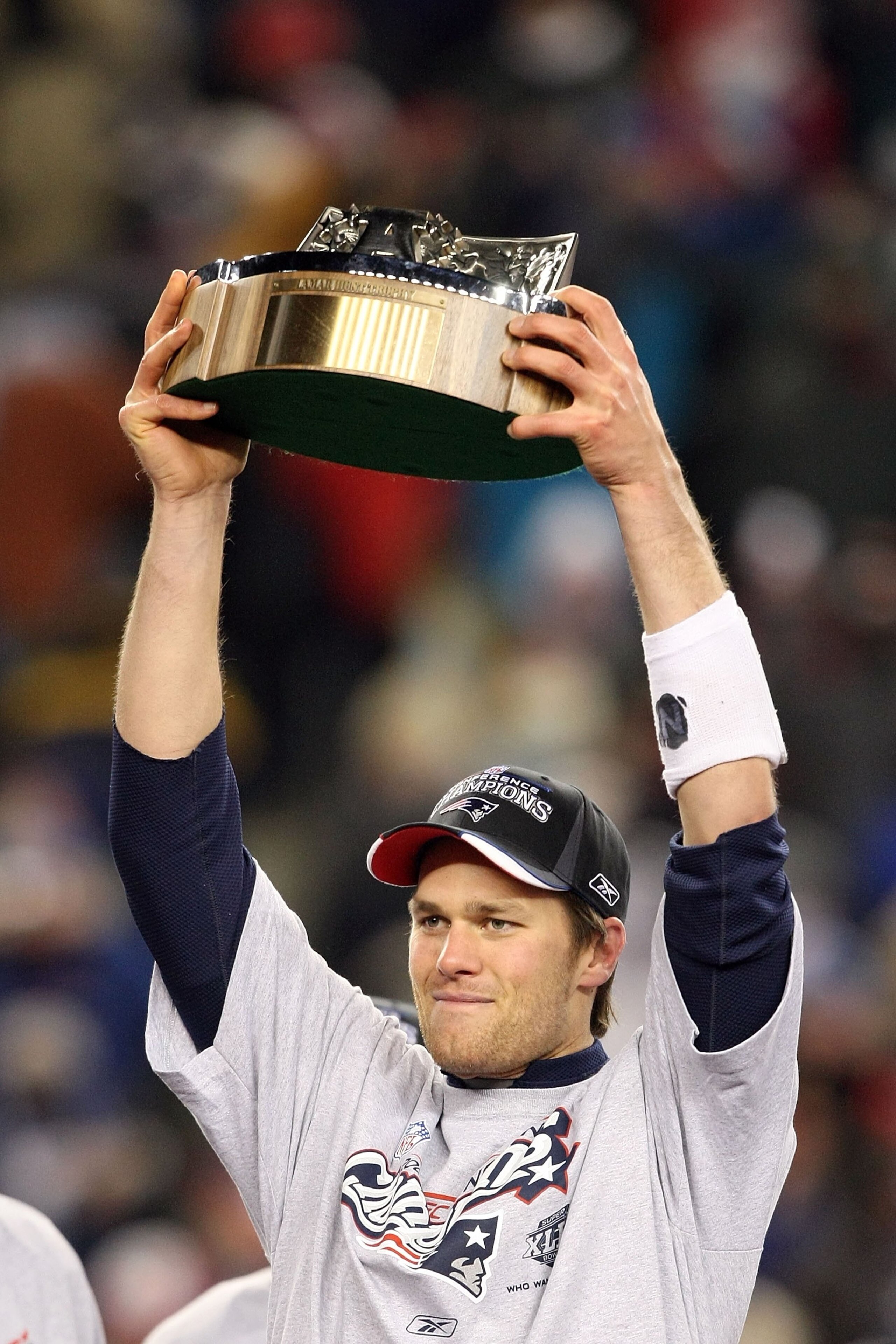 FOXBORO, MA - JANUARY 20:  Tom Brady #12 of the New England Patriots holds up the Lamar Hunt AFC Championship trophy after the Patriots won 21-12 against the San Diego Chargers during the AFC Championship Game on January 20, 2008 at Gillette Stadium in Fo