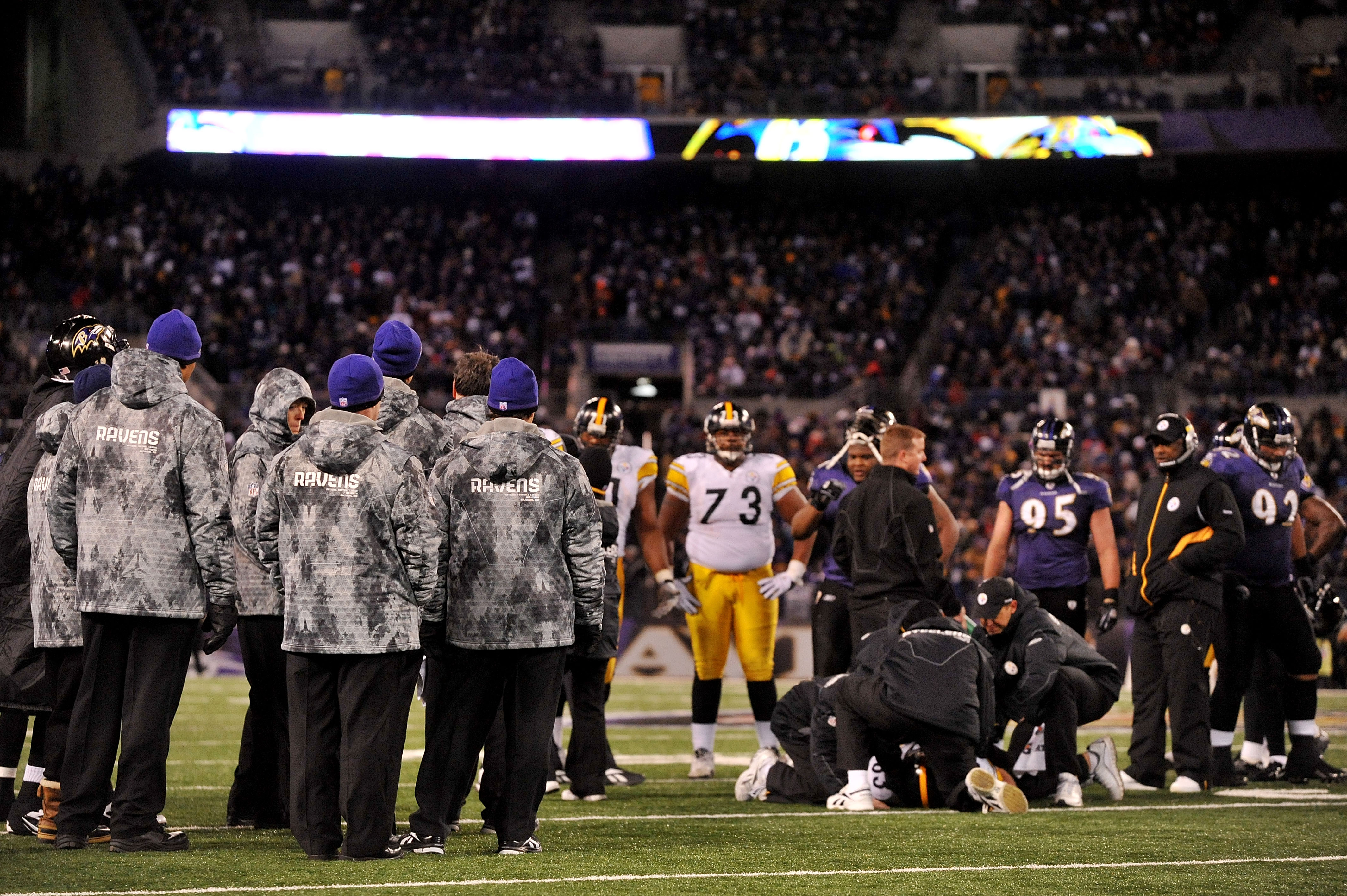 BALTIMORE, MD - DECEMBER 05:  The Baltimore Ravens and the Pittsburgh Steelers look on while tight end Heath Miller #83 of the Pittsburgh Steelers is tended to on the field after being injured during the third quarter of the game at M&T Bank Stadium on De