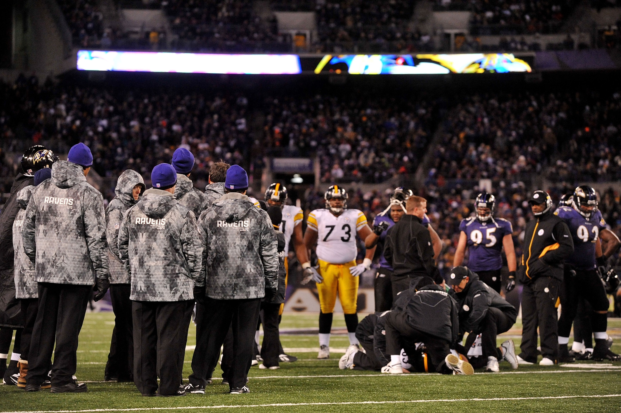 BALTIMORE, MD - DECEMBER 05:  The Baltimore Ravens and the Pittsburgh Steelers look on while tight end Heath Miller #83 of the Pittsburgh Steelers is tended to on the field after being injured during the third quarter of the game at M&T Bank Stadium on De