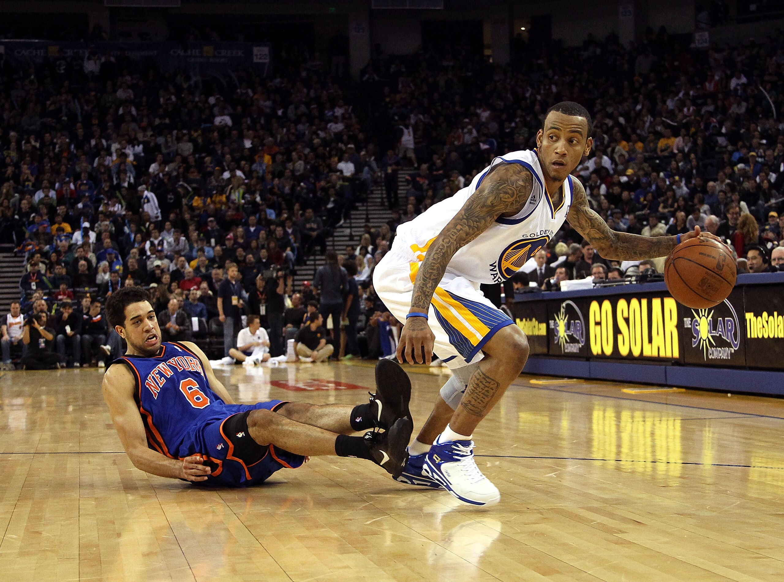 OAKLAND, CA - NOVEMBER 19: Monta Ellis #8 of the Golden State Warriors dribbles the ball after Danillo Gallinari #8 of the New York Knicks falls down at Oracle Arena on November 19, 2010 in Oakland, California. NOTE TO USER: User expressly acknowledges a OAKLAND, CA - NOVEMBER 19: Monta Ellis #8 of the Golden State Warriors dribbles the ball after Danillo Gallinari #8 of the New York Knicks falls down at Oracle Arena on November 19, 2010 in Oakland, California. NOTE TO USER: User expressly acknowledges a