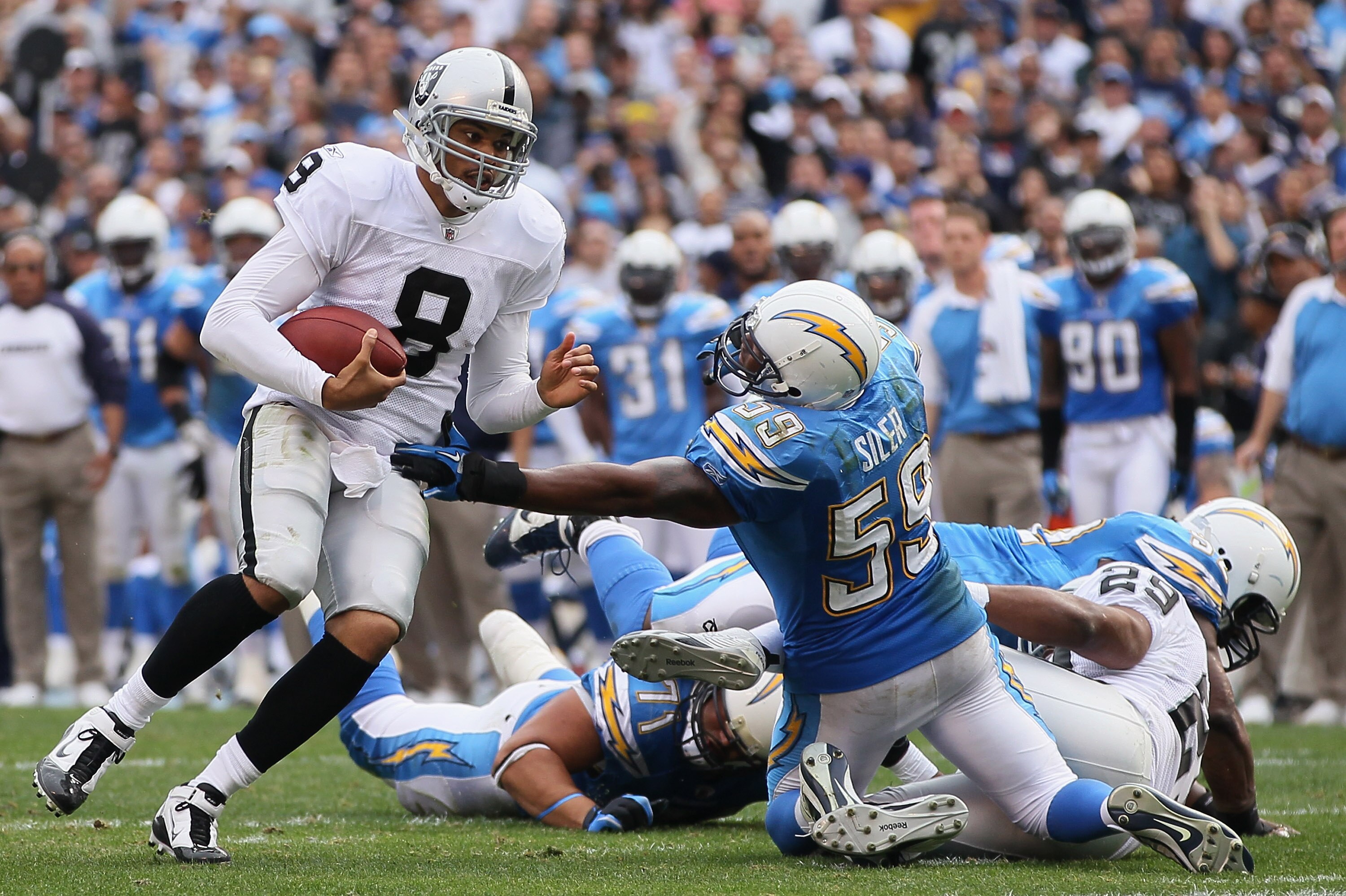 SAN DIEGO - DECEMBER 05:  Quarterback Jason Campbell #8 the Oakland Raiders breaks the tackle of Brandon Siler #59 of the San Diego Chargers in the second quarter at Qualcomm Stadium on December 5, 2010 in San Diego, California. The Raiders defeated the C
