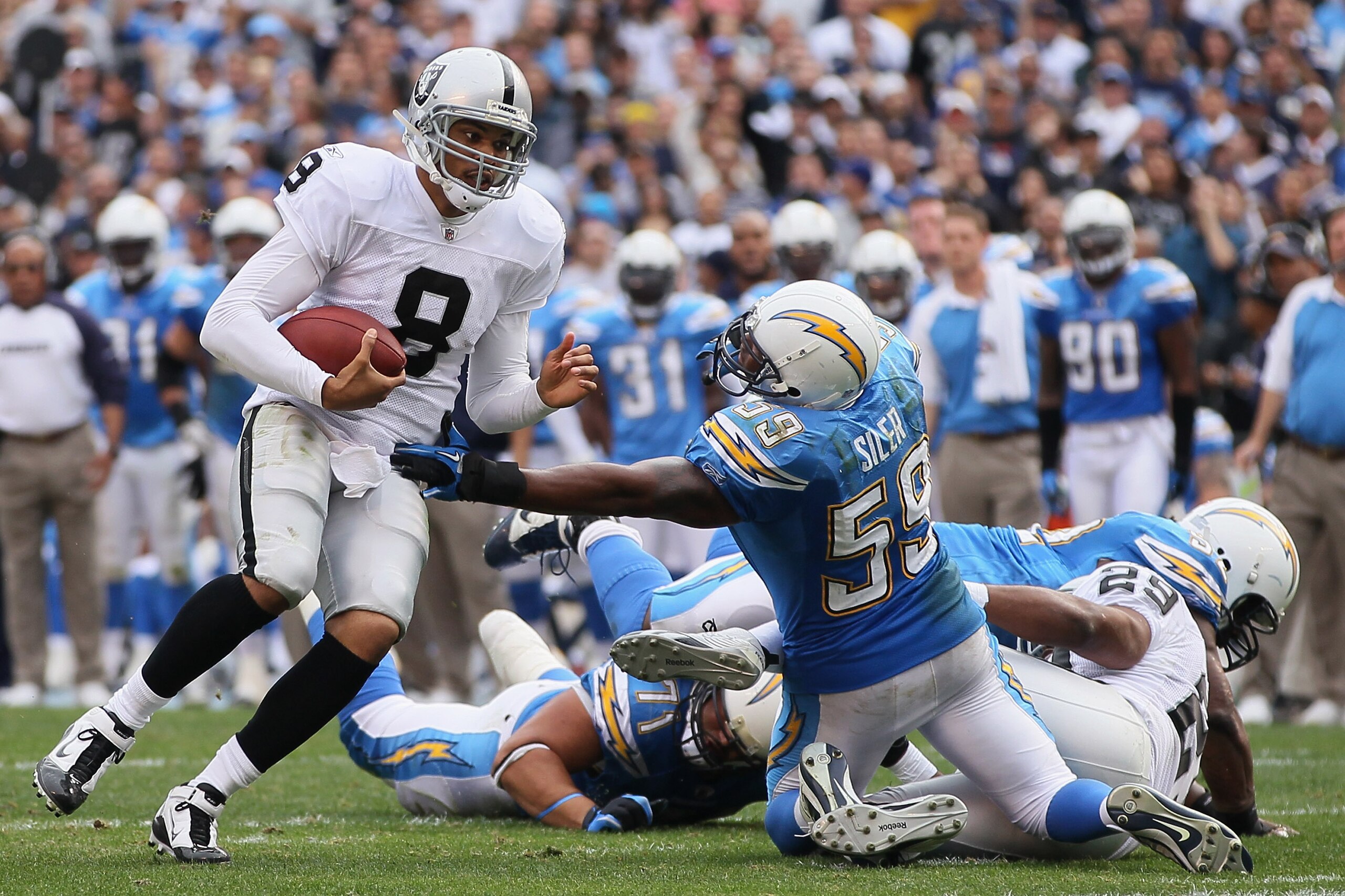SAN DIEGO - DECEMBER 05:  Quarterback Jason Campbell #8 the Oakland Raiders breaks the tackle of Brandon Siler #59 of the San Diego Chargers in the second quarter at Qualcomm Stadium on December 5, 2010 in San Diego, California. The Raiders defeated the C