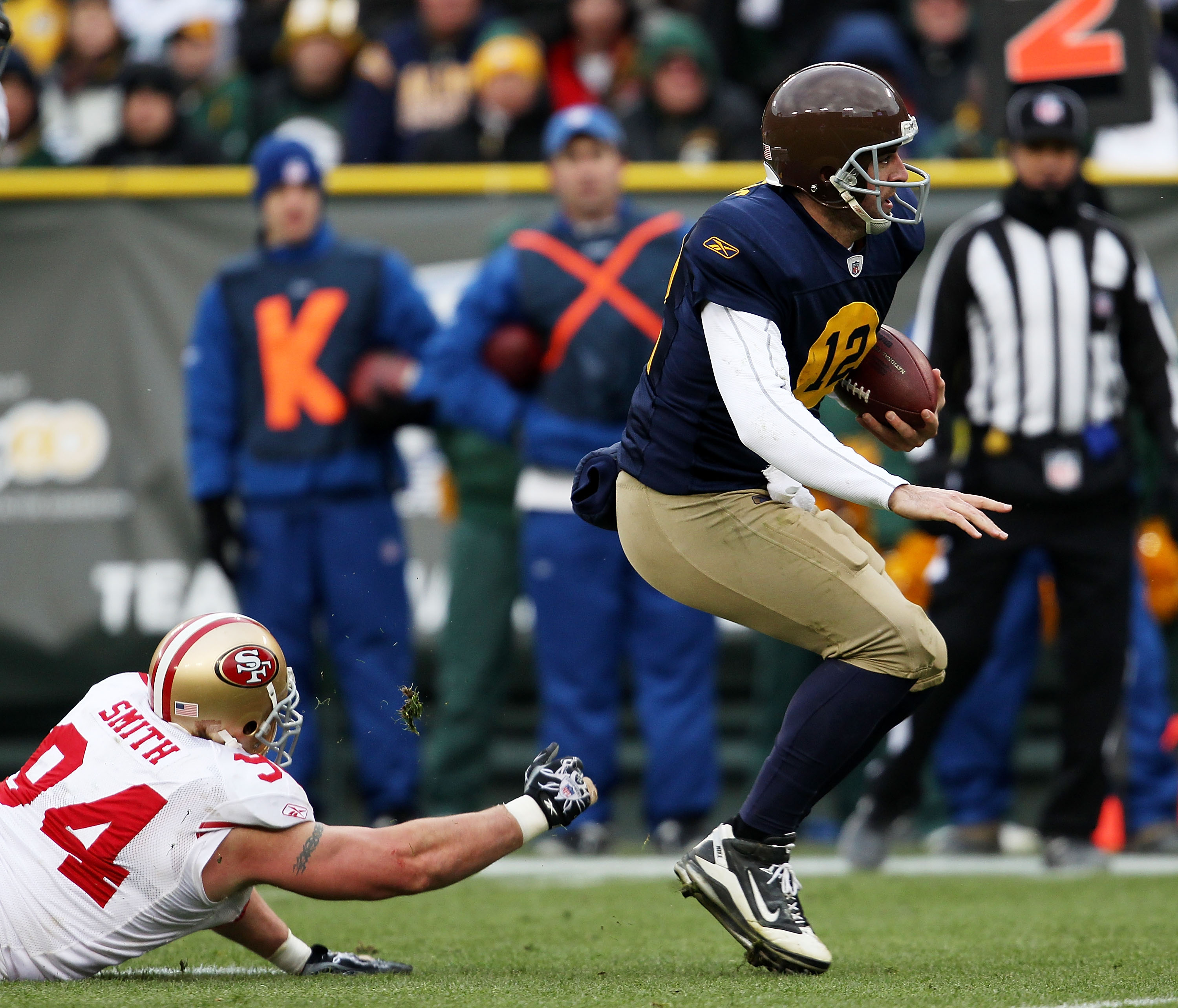 GREEN BAY, WI - DECEMBER 05: Aaron Rodgers #12 of the Green Bay Packers breaks away from Justin Smith #94 of the San Francisco 49ers on a run for a first down at Lambeau Field on December 5, 2010 in Green Bay, Wisconsin. The Packers defeated the 49ers 34-