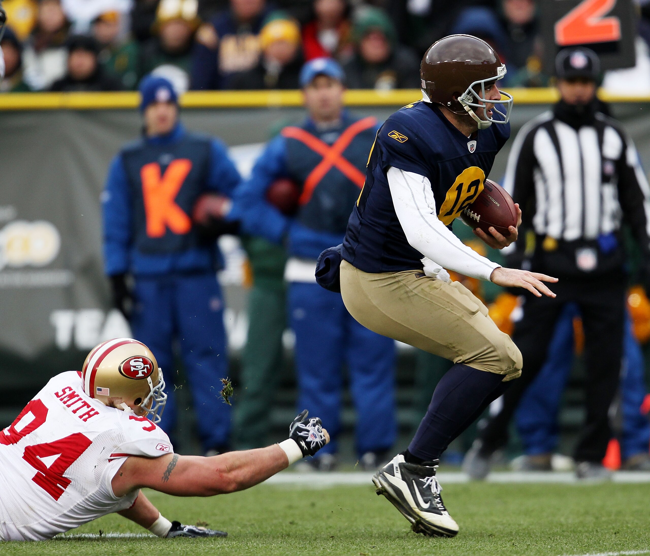 GREEN BAY, WI - DECEMBER 05: Aaron Rodgers #12 of the Green Bay Packers breaks away from Justin Smith #94 of the San Francisco 49ers on a run for a first down at Lambeau Field on December 5, 2010 in Green Bay, Wisconsin. The Packers defeated the 49ers 34-