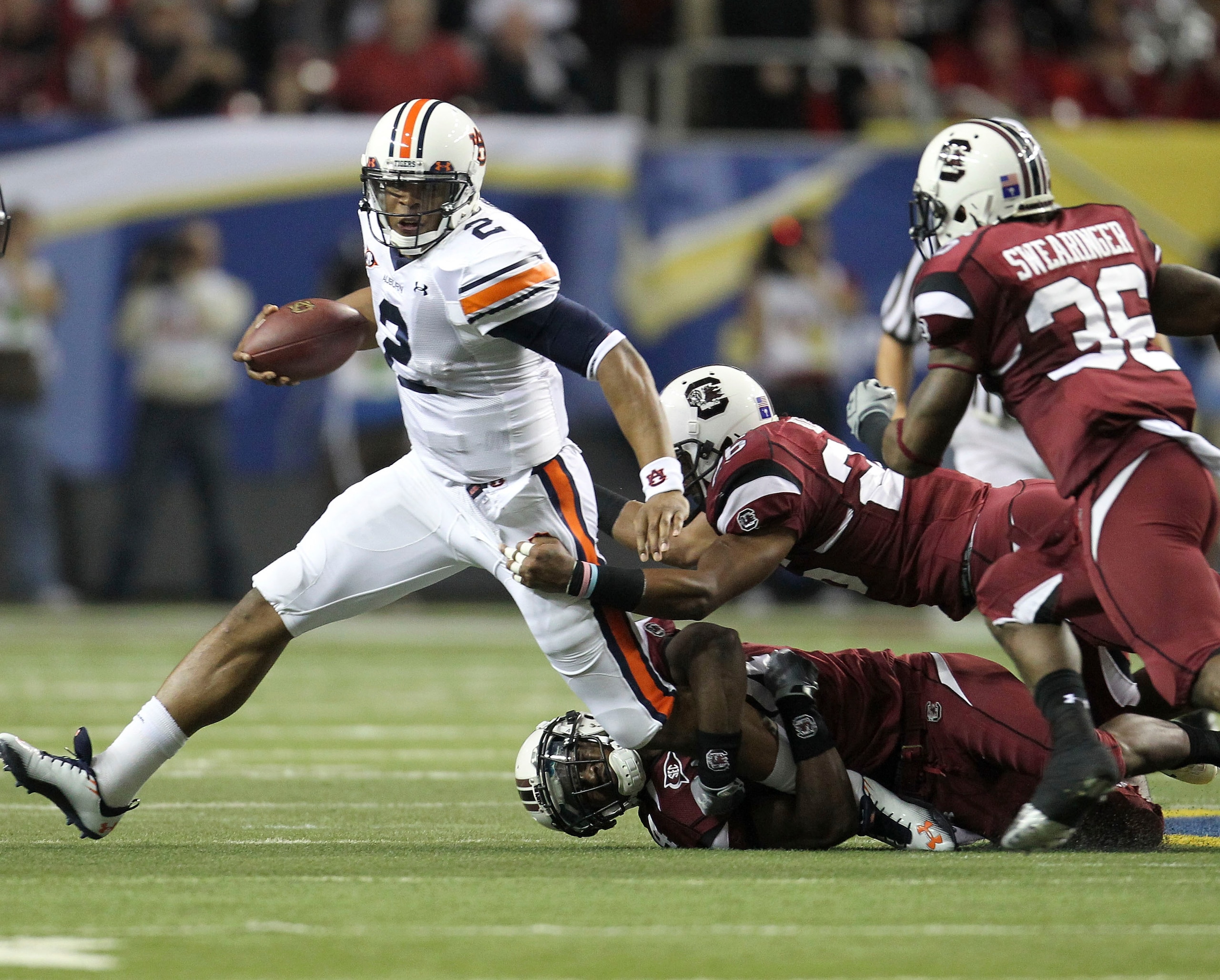ATLANTA - DECEMBER 4: Quarterback Cam Newton #2 of the Auburn Tigers is pursued by members of the South Carolina Gamecocks defense during the 2010 SEC Championship against the Auburn Tigers South Carolina Gamecocks at Georgia Dome on December 4, 2010 in ATLANTA - DECEMBER 4: Quarterback Cam Newton #2 of the Auburn Tigers is pursued by members of the South Carolina Gamecocks defense during the 2010 SEC Championship against the Auburn Tigers South Carolina Gamecocks at Georgia Dome on December 4, 2010 in