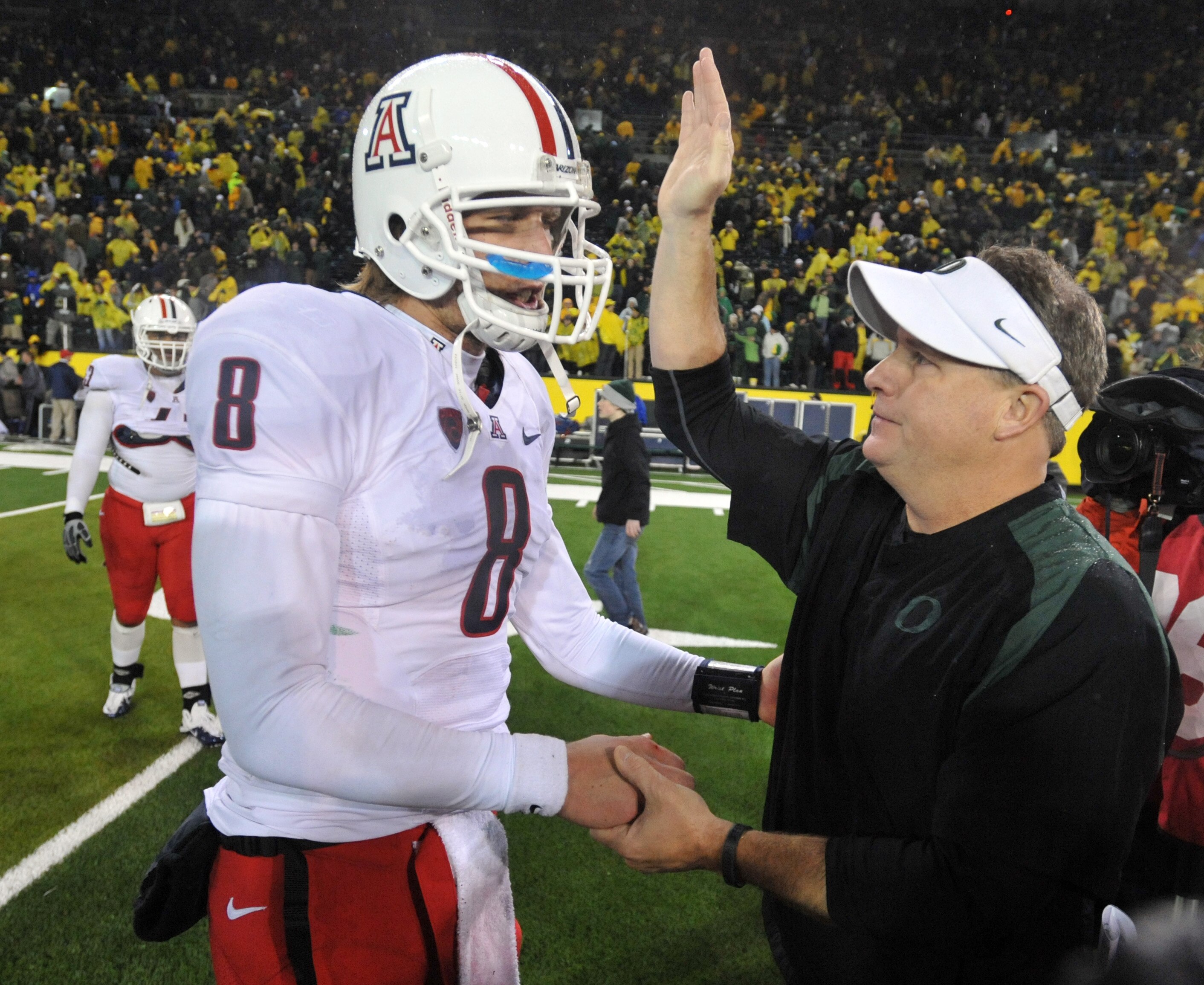 EUGENE, OR - NOVEMBER 26: Quarterback Nick Foles #8 of the Arizona Wildcats is greeted by head coach Chip Kelly of the Oregon Ducks after the game at Autzen Stadium on November 26, 2010 in Eugene, Oregon. The Ducks won the game 48-29. (Photo by Steve Dyke