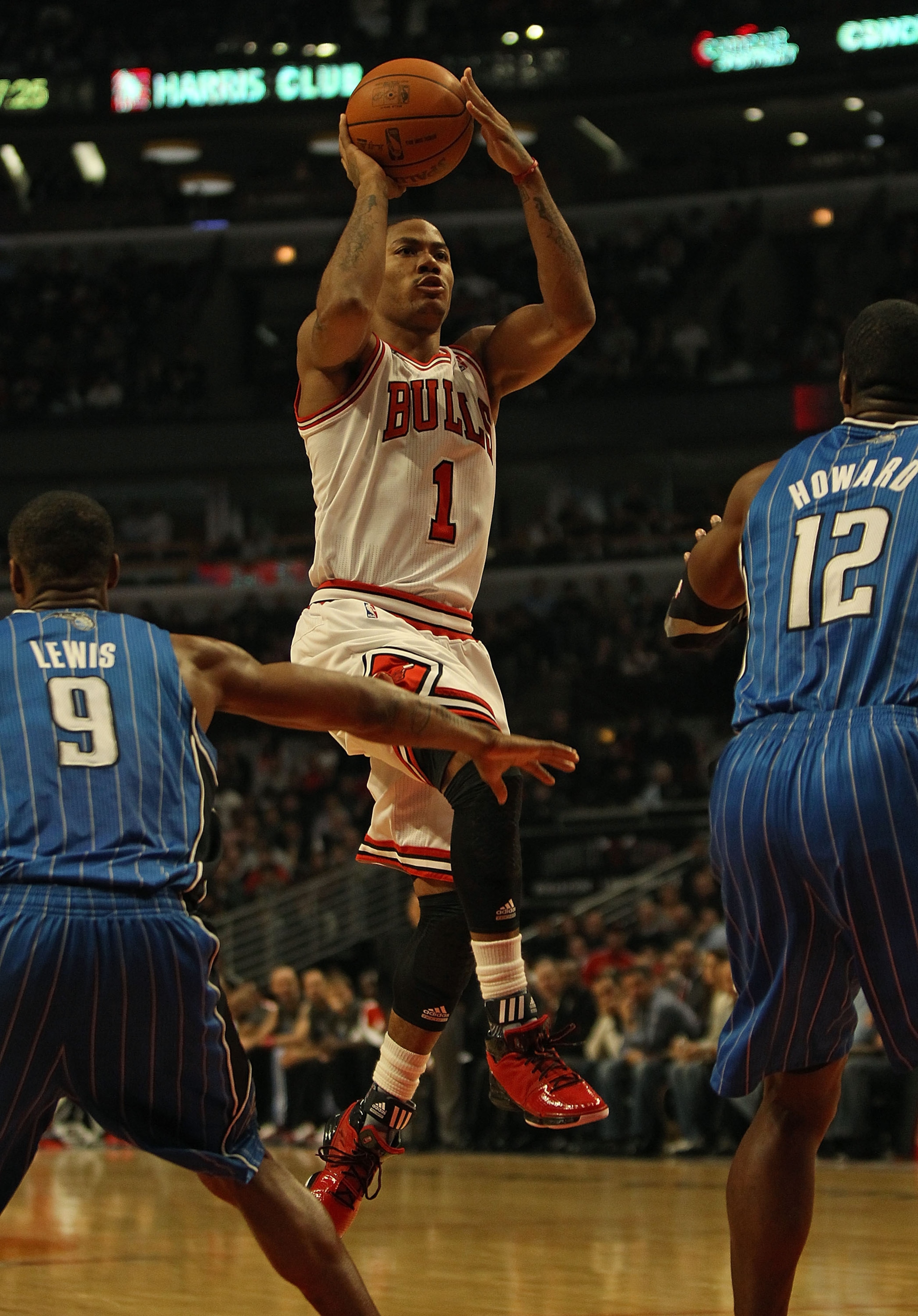 CHICAGO, IL - DECEMBER 01: Derrick Rose #1 of the Chicago Bulls shoots against Rashard Lewis #9 and Dwight Howard #12 of the Orlando Magic at the United Center on December 1, 2010 in Chicago, Illinois. The Magic defeated the Bulls 107-78. NOTE TO USER: Us