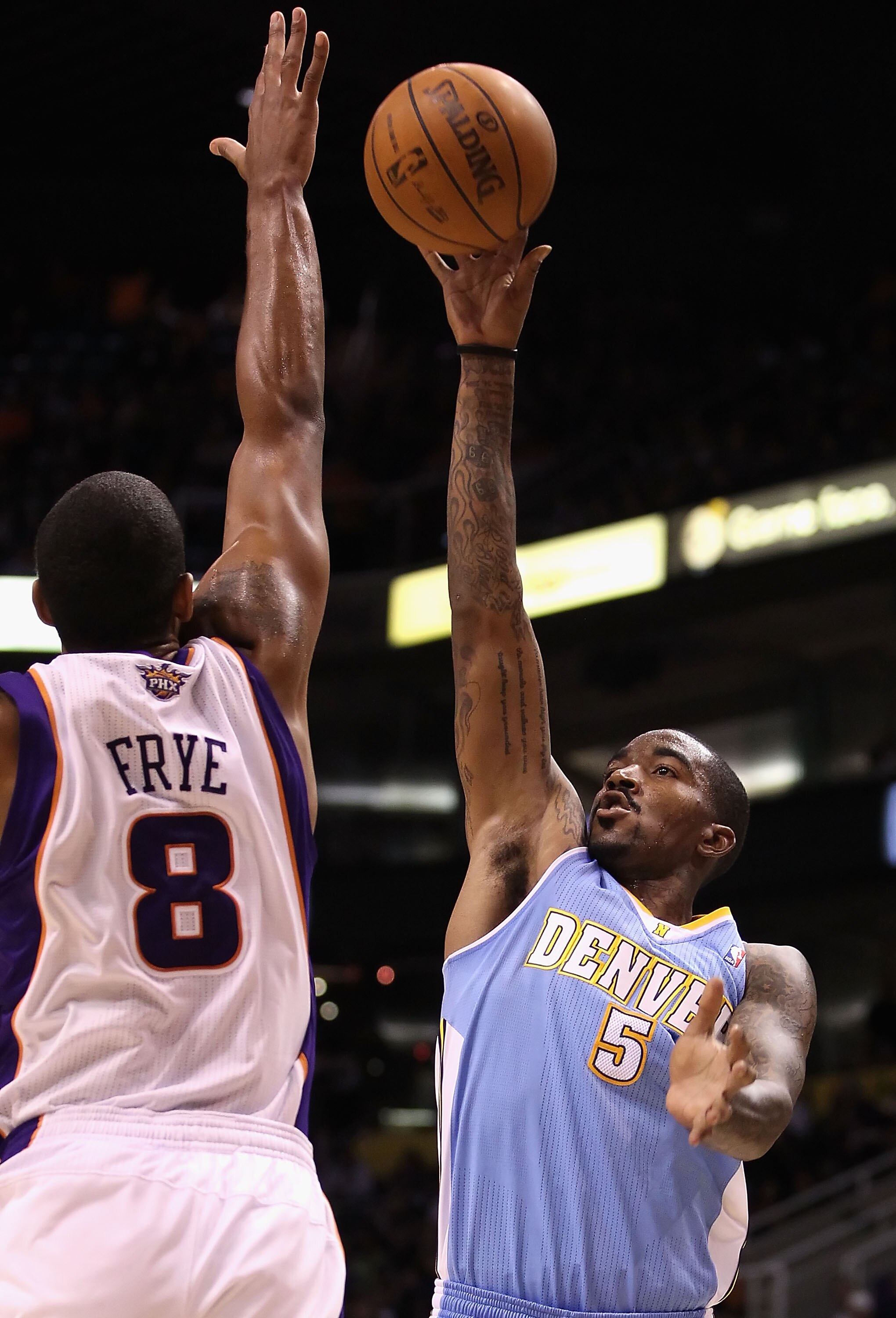 PHOENIX - OCTOBER 22:  J.R. Smith #5 of the Denver Nuggets puts up a shot over Channing Frye #8 of the Phoenix Suns during the preseason NBA game at US Airways Center on October 22, 2010 in Phoenix, Arizona. NOTE TO USER: User expressly acknowledges and a