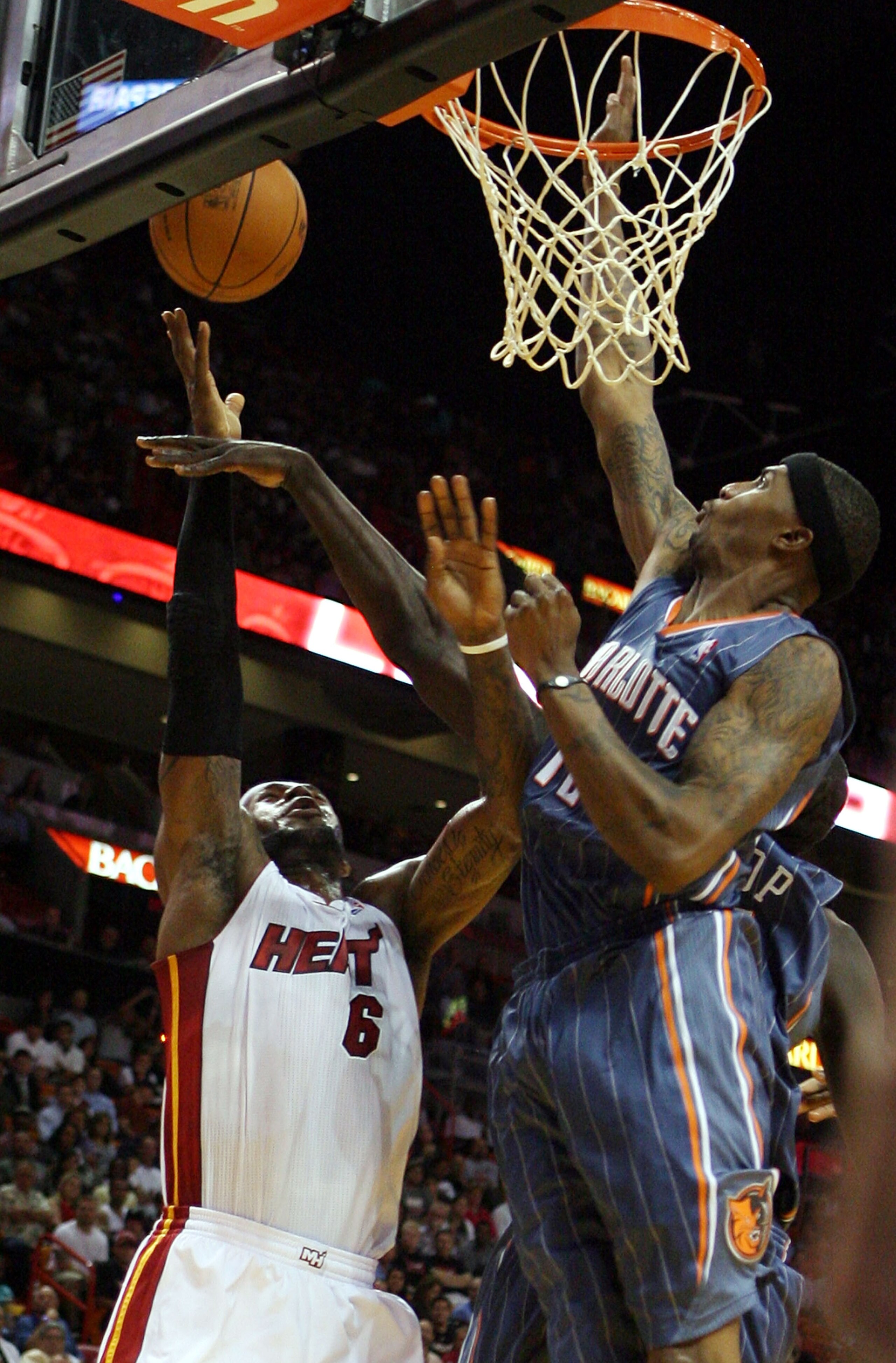MIAMI - OCTOBER 18:  Forward LeBron James #6 of the Miami Heat is fouled by Forward Tyrus Thomas #12  of the Charlotte Bobcats on October 18, 2010 at the American Airlines Arena in Miami, Florida.  NOTE TO USER: User expressly acknowledges and agrees that