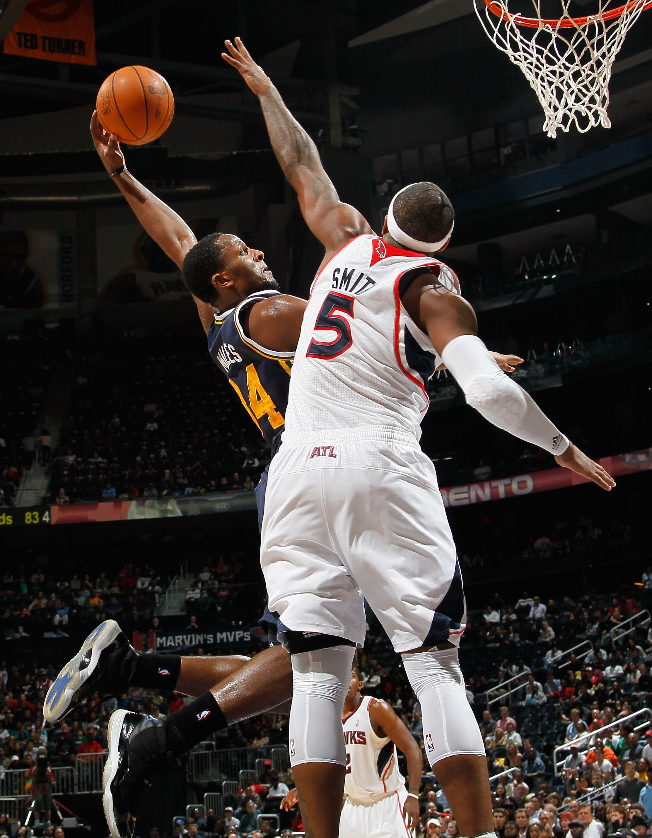 ATLANTA - NOVEMBER 12:  Josh Smith #5 of the Atlanta Hawks leaps to block a dunk by C.J. Miles #34 of the Utah Jazz at Philips Arena on November 12, 2010 in Atlanta, Georgia.  NOTE TO USER: User expressly acknowledges and agrees that, by downloading and/o