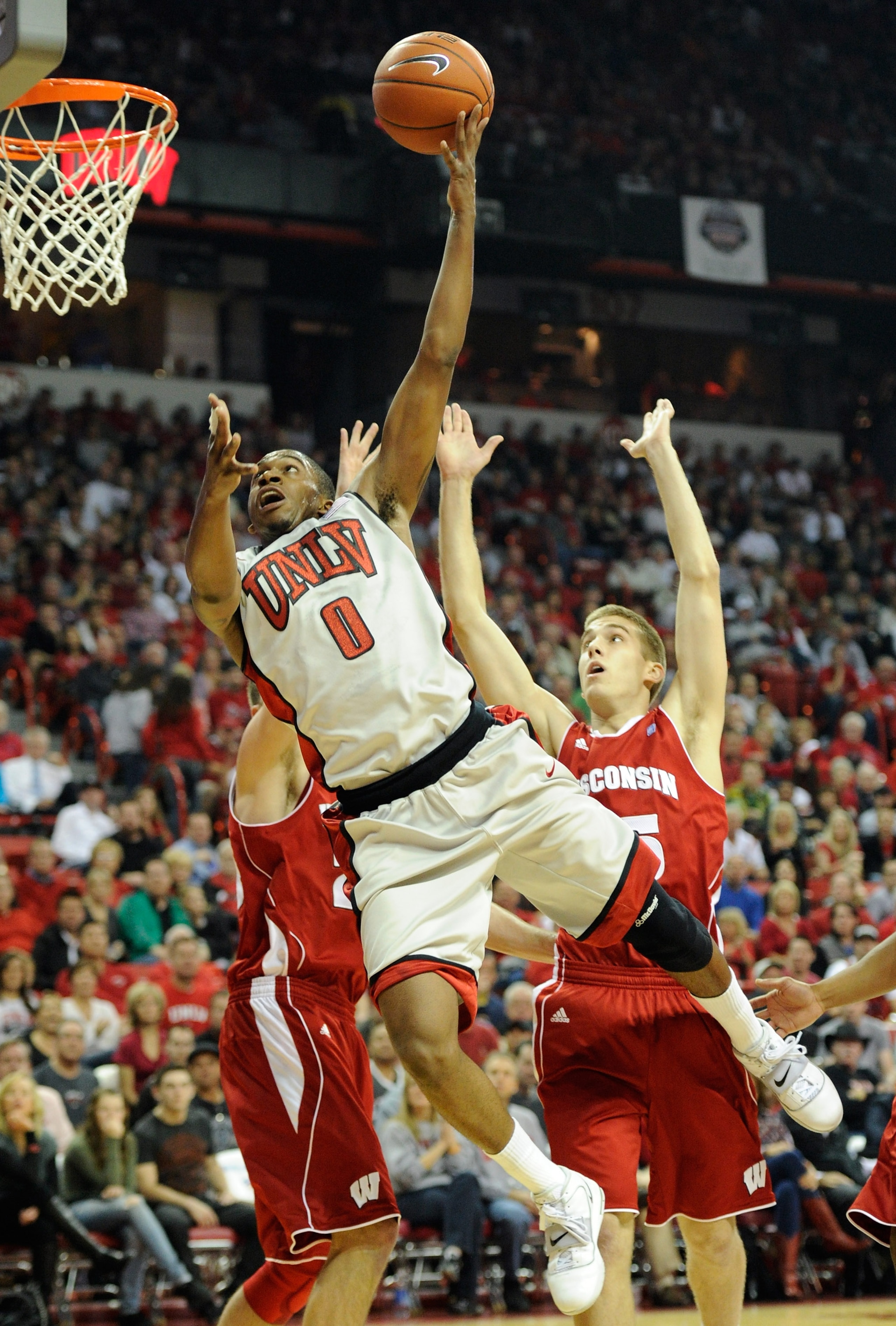 LAS VEGAS - NOVEMBER 20:  Oscar Bellfield #0 of the UNLV Rebels drives against Brett Valentyn (R) #15 of the Wisconsin Badgers during their game at the Thomas & Mack Center November 20, 2010 in Las Vegas, Nevada.  (Photo by Ethan Miller/Getty Images)