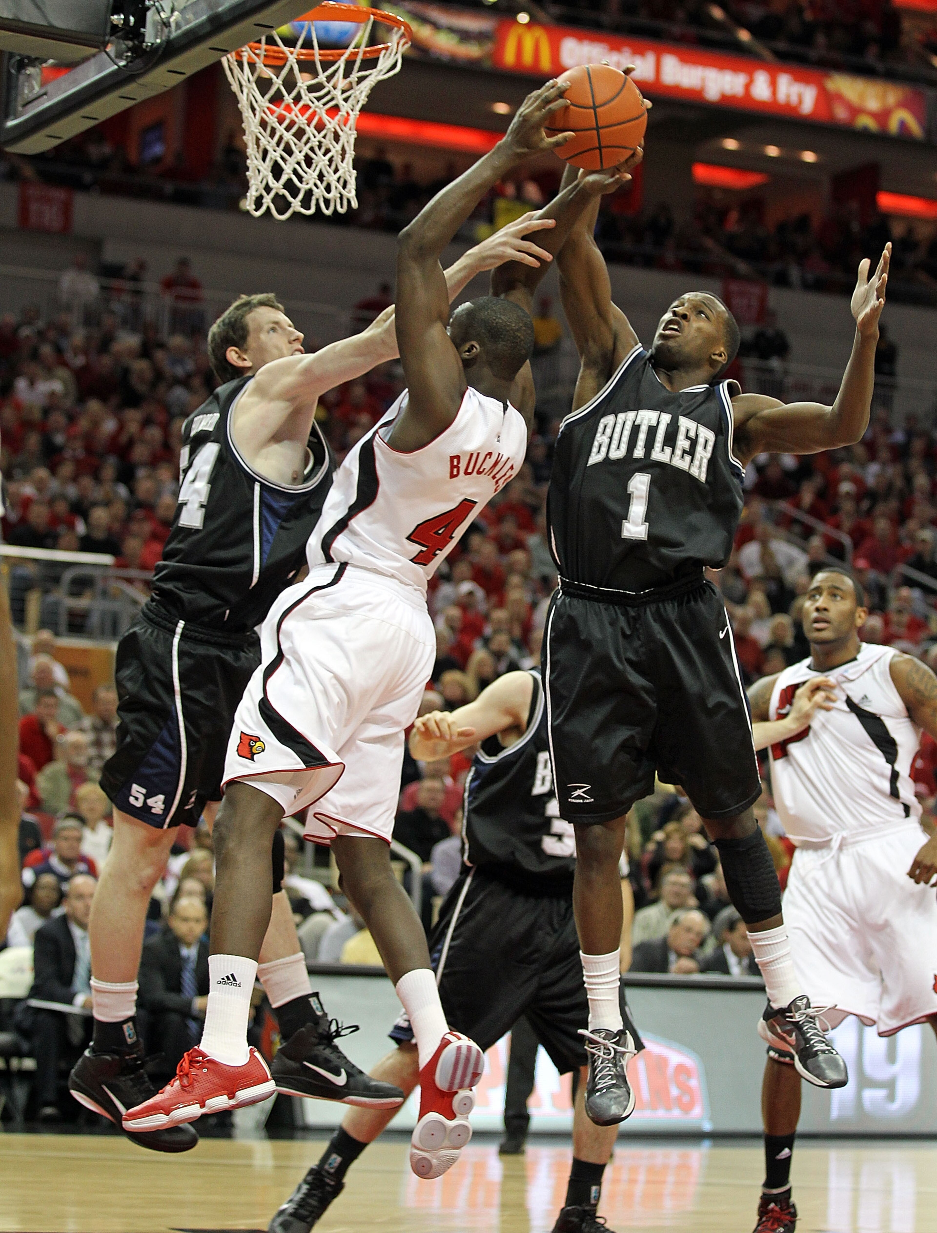 LOUISVILLE, KY - NOVEMBER 16:  Matt Howard #54 and Shelvin Mack #1 of the Butler Bulldogs defend the shot of  Rakeem Buckles #4 of the Louisville Cardinals during the game at the KFC Yum! Center on November 16, 2010 in Louisville, Kentucky.  (Photo by And