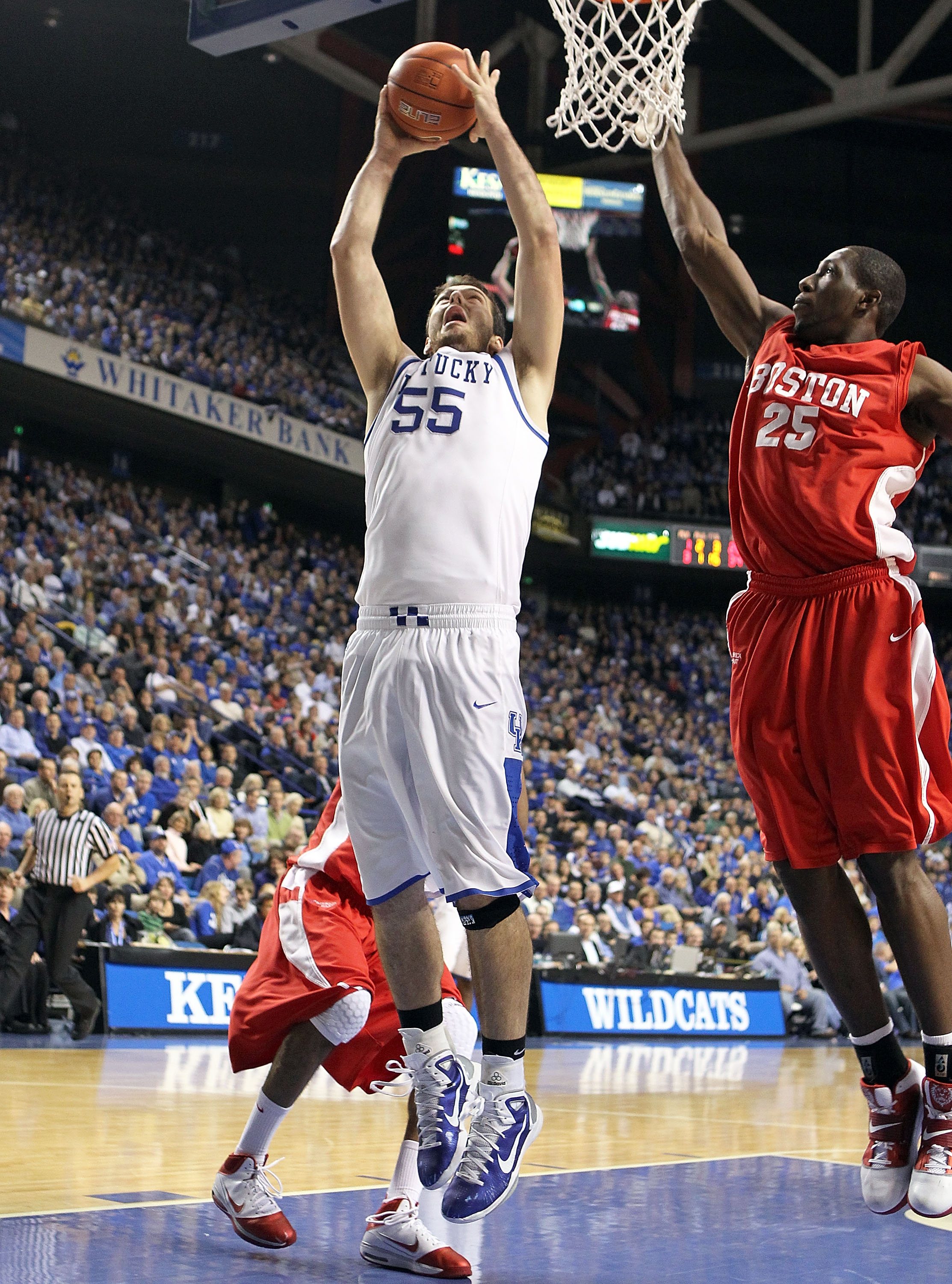 LEXINGTON, KY - NOVEMBER 30: Josh Harrellson #55 of the Kentucky Wildcats shoots the ball while defended by Patrick Hazel #25 of the Boston University Terriers during the game on November 30, 2010 in Lexington, Kentucky. Kentucky won 91-57. (Photo by Andy