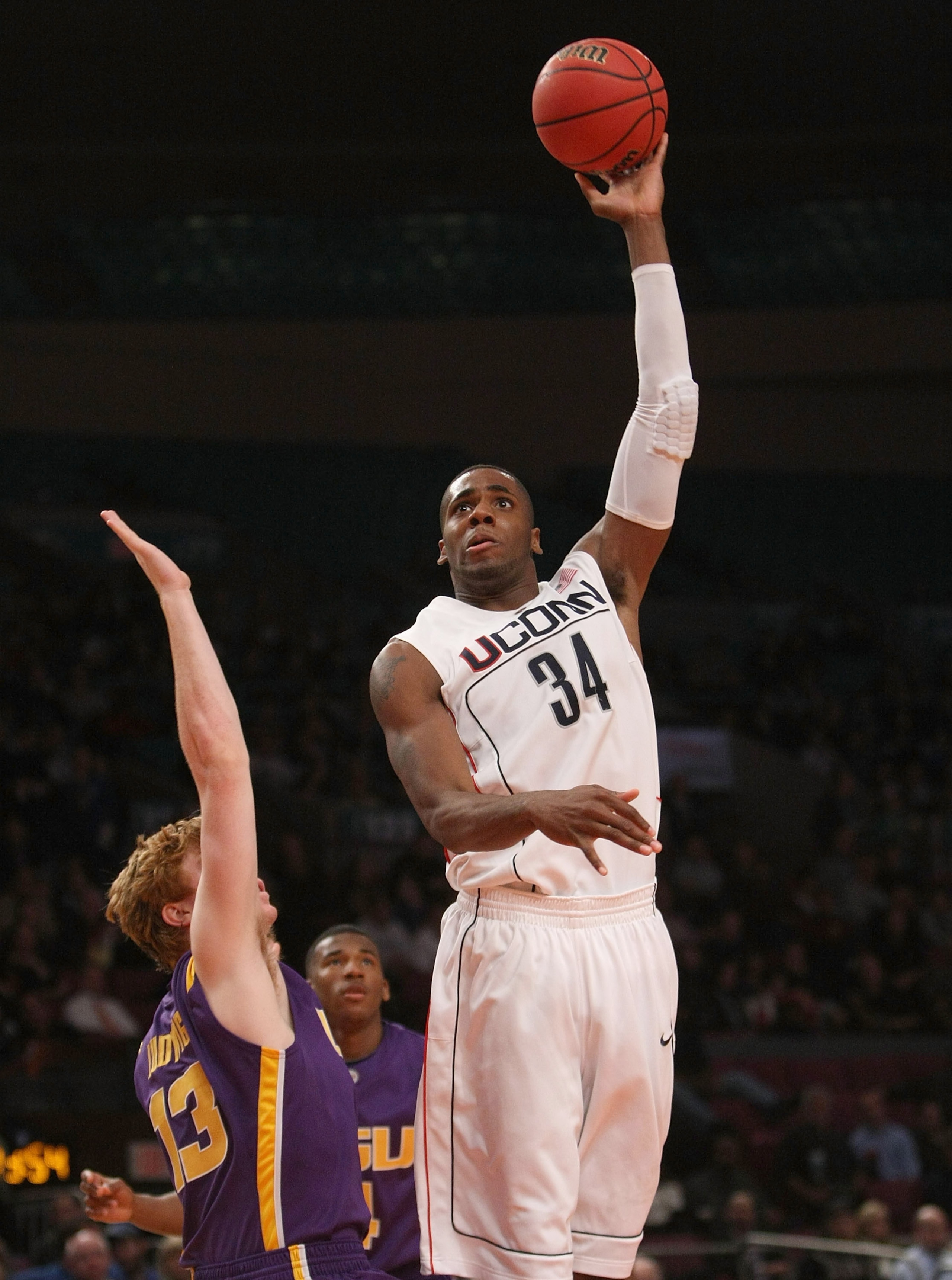 NEW YORK - NOVEMBER 25:  Alex Oriakhi #34 of the Connecticut Huskies shoots the ball over Eddie Ludwig #13 of the LSU Tigers at Madison Square Garden on November 25, 2009 in New York, New York.  (Photo by Nick Laham/Getty Images)