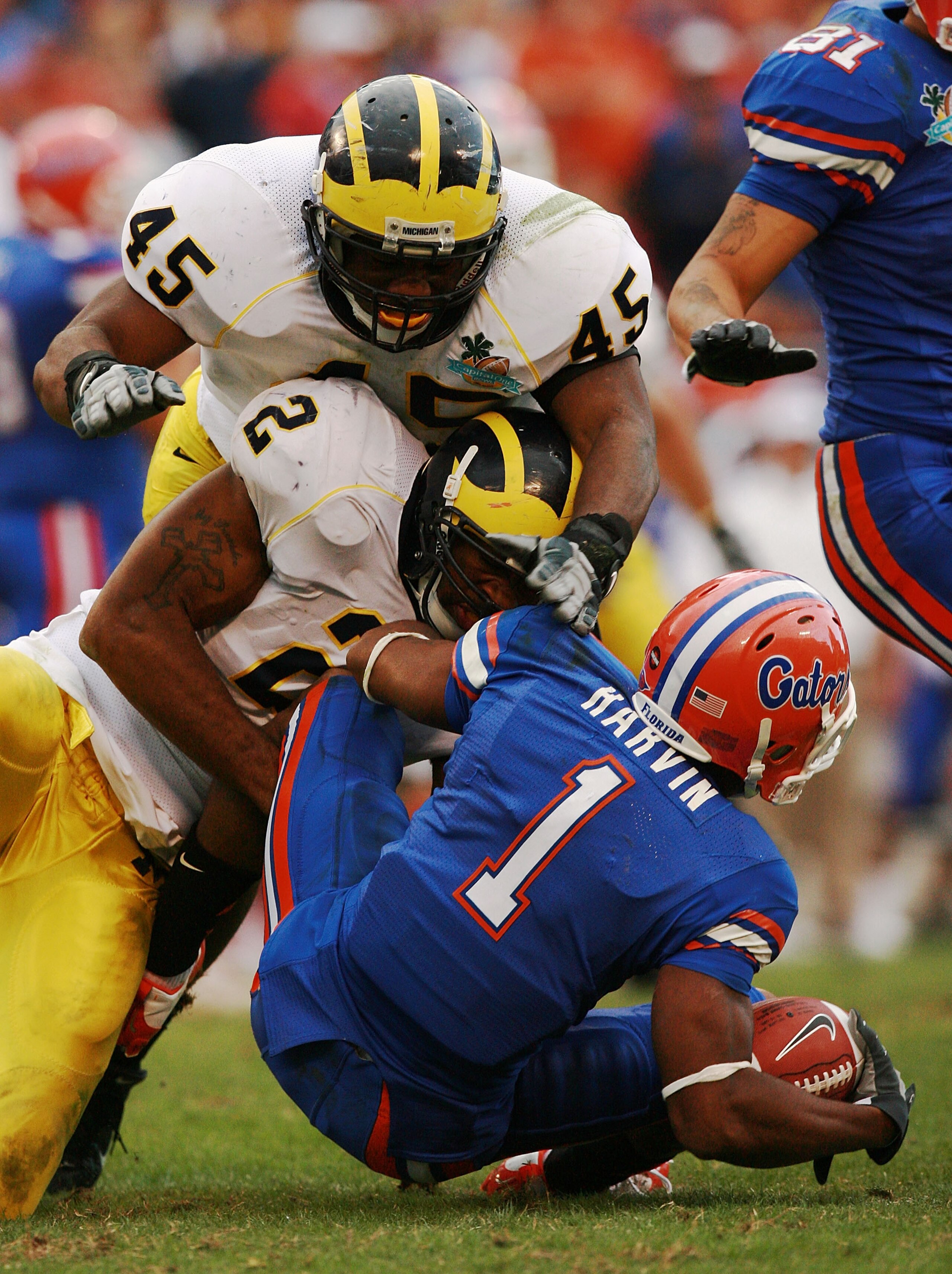 ORLANDO, FL - JANUARY 01:  Wide receiver Percy Harvin #1 of the Florida Gators is brought down by linebackers Shawn Crable #2 and Obi Ezeh #45 of the Michigan Wolverines in the Capital One Bowl at Florida Citrus Bowl on January 1, 2008 in Orlando, Florida