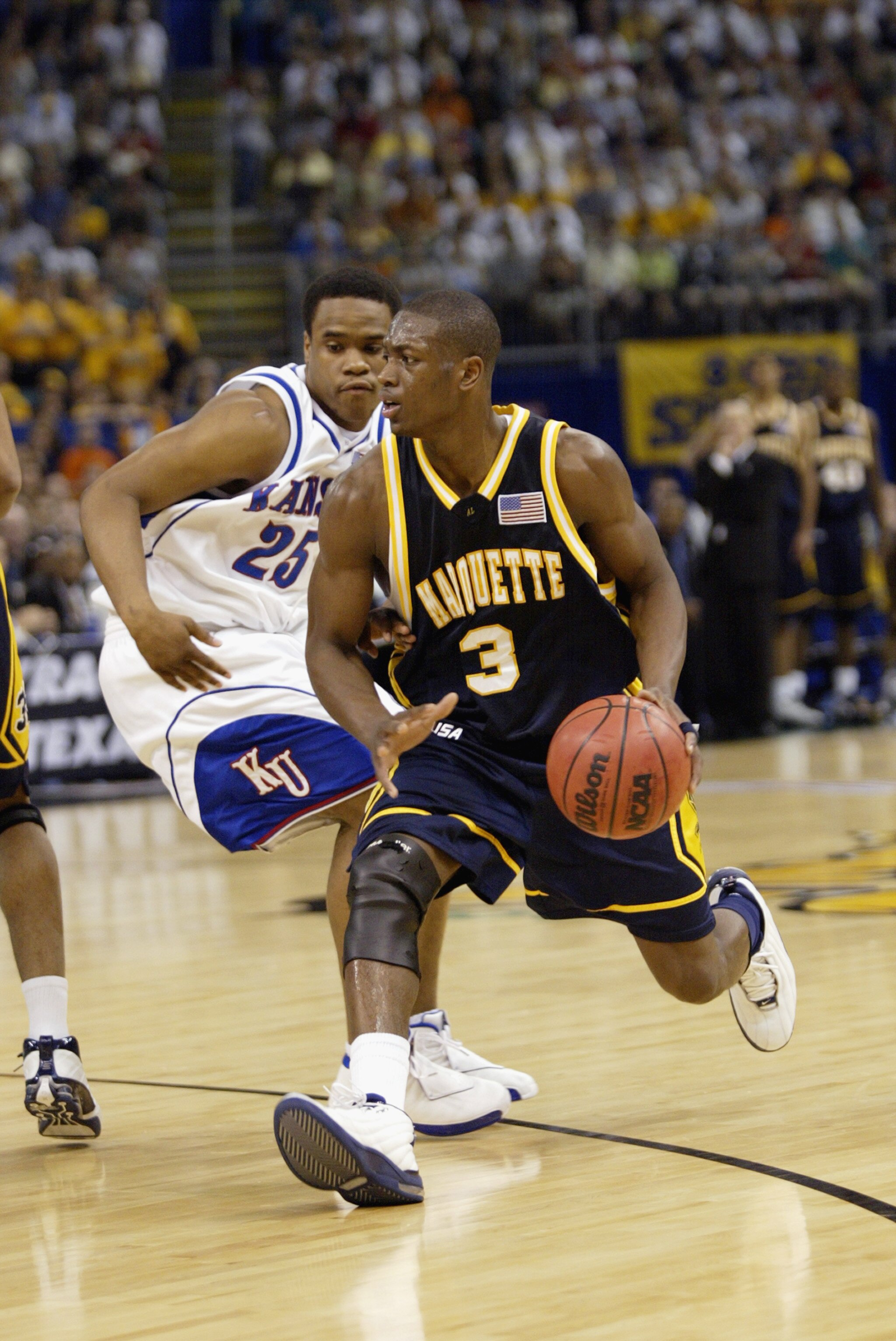 NEW ORLEANS - APRIL 5:  Dwyane Wade #3 of Marquette University Golden Eagles drives past Michael Lee #25 of the University of Kansas Jayhawks during the semifinal round of the NCAA Final Four Tournament at the Louisiana Superdome on April 5, 2003 in New O