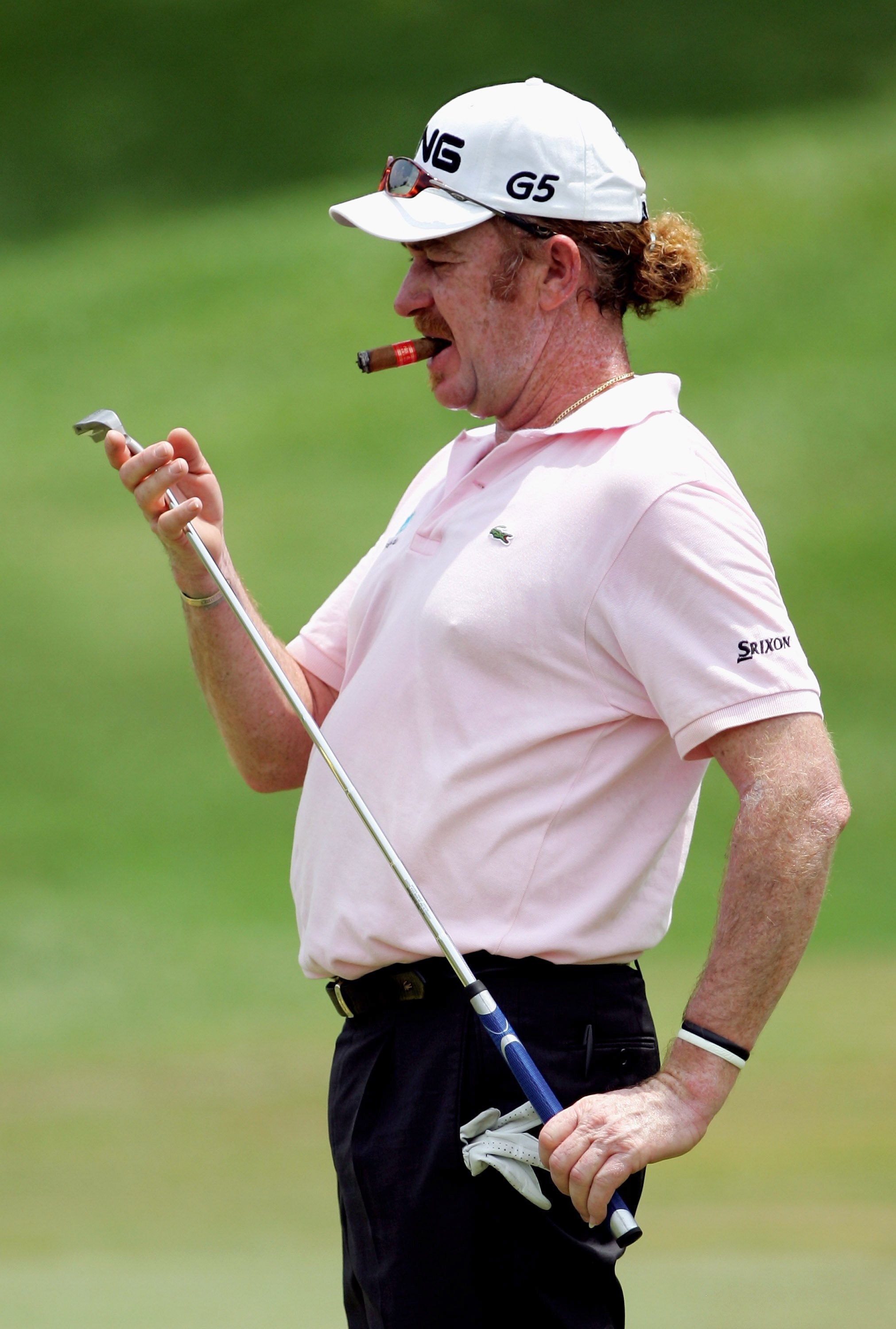KUALA LUMPUR, MALAYSIA - FEBRUARY 15:  Miguel Angel Jimenez of Spain inspects his putter on the first green as he puffs on a cigar during the practice round of the Maybank Malaysian Open 2006 at Kuala Lumpur Golf and Country Club on February 15, 2006 in K
