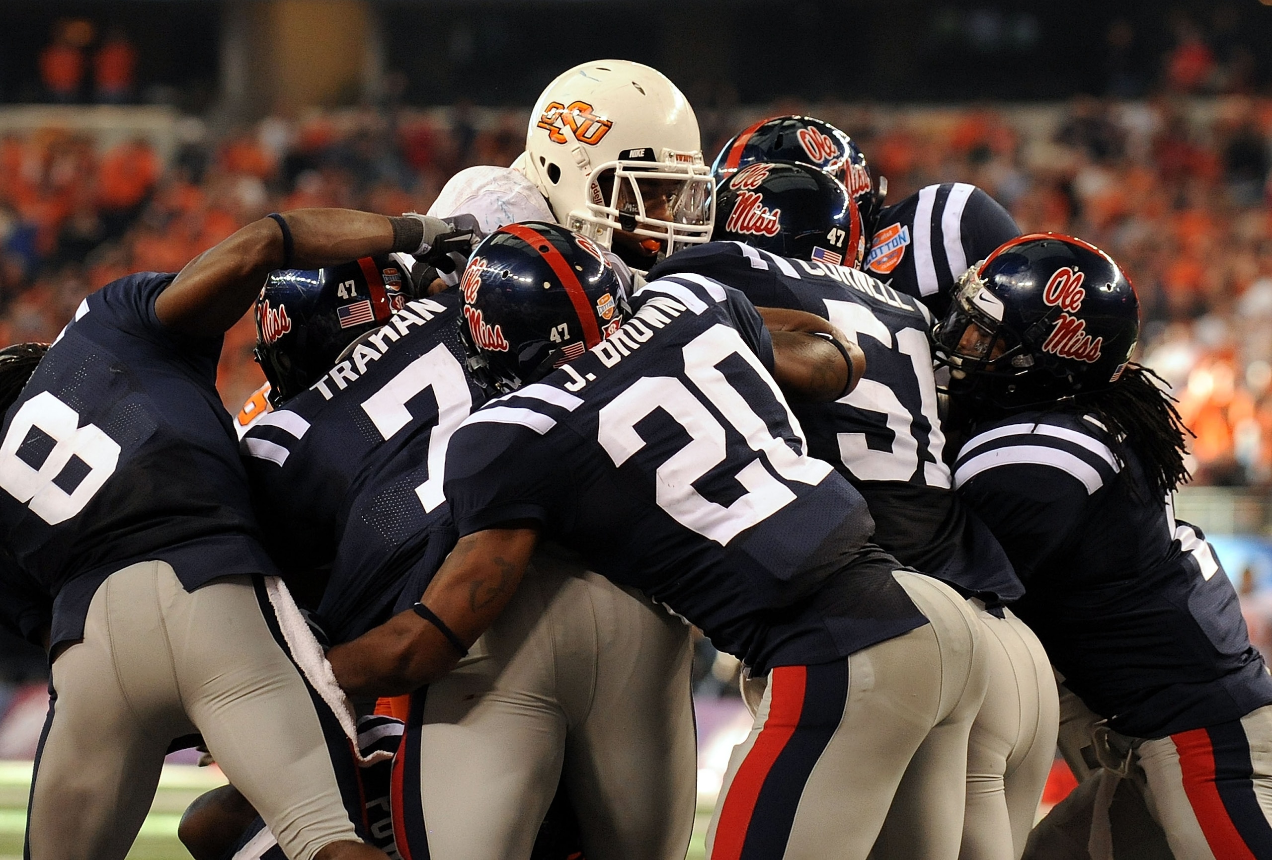ARLINGTON, TX - JANUARY 02:  Keith Tolston #5 of the Oklahoma State Cowboys is stopped by the defense of the Mississippi Rebels on 4th and goal during the AT&T Cotton Bowl on January 2, 2010 at Cowboys Stadium in Arlington, Texas.  (Photo by Ronald Martin